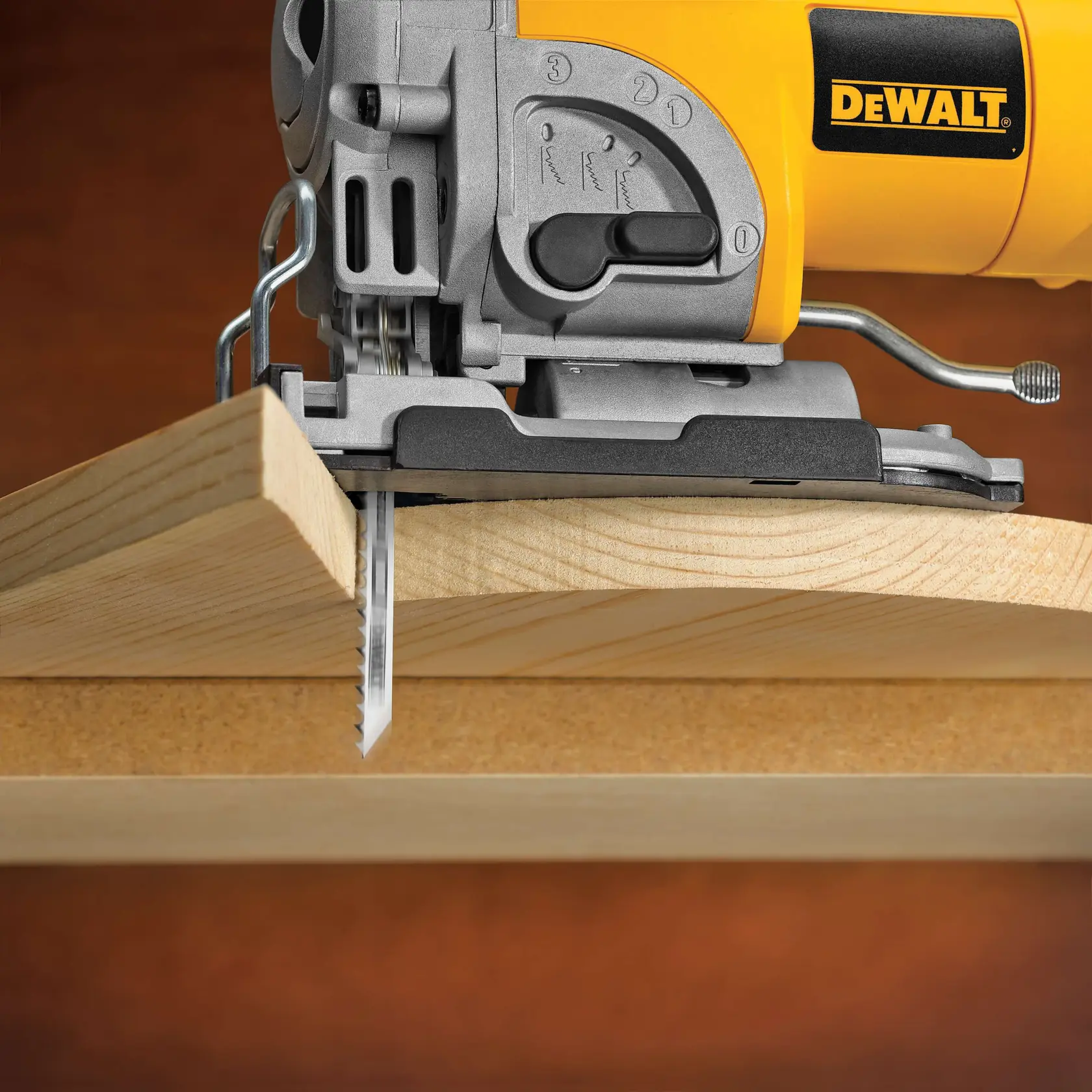 Close-up of a DEWALT jigsaw cutting through a piece of wood at an angle.