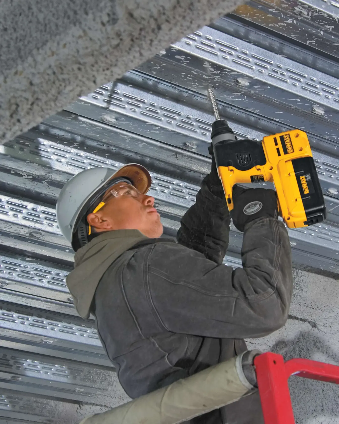 Three eighths inch by 4 inch by 6 and half inch S D S Plus Full Head Carbide Drill Bit being used by worker to drill through metal ceiling.