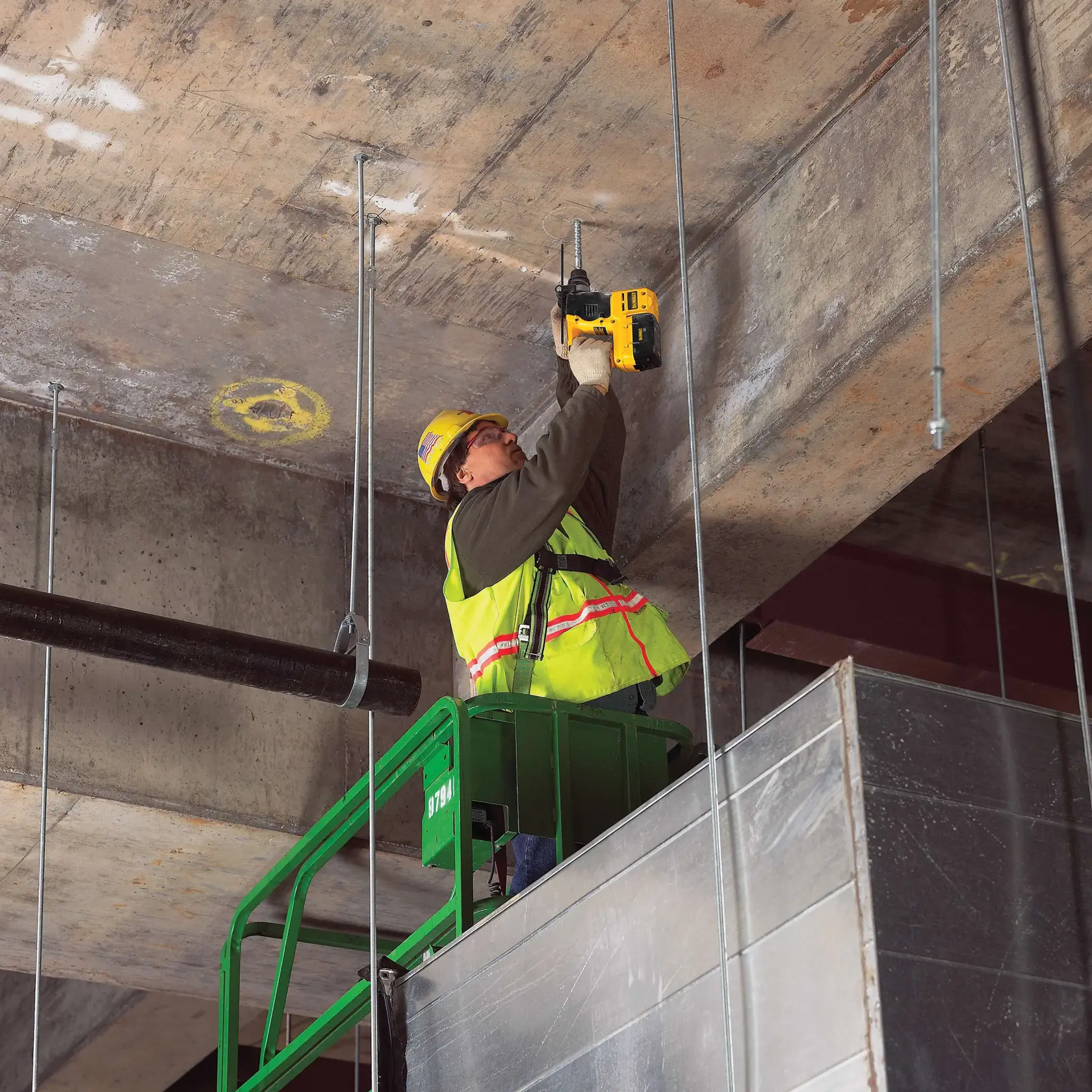 Three eighths inch by 4 inch by 6 and half inch S D S Plus Full Head Carbide Drill Bit being used by worker to drill through ceiling.