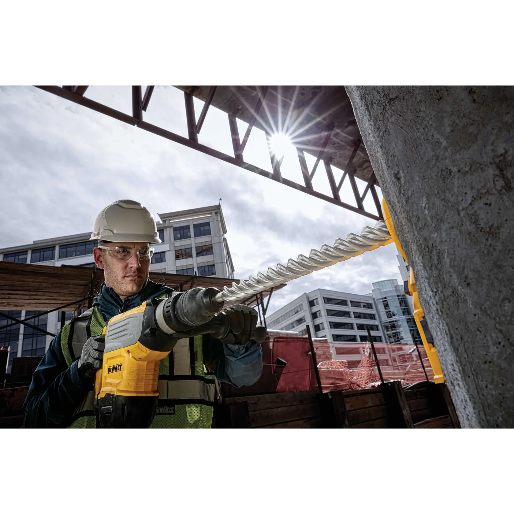 1 and 9 sixteenths inch by 18 inch by 22 and half inch S D S Max High Impact Carbide 4 Cutter Drill Bit being used by worker to drill into wall at jobsite.