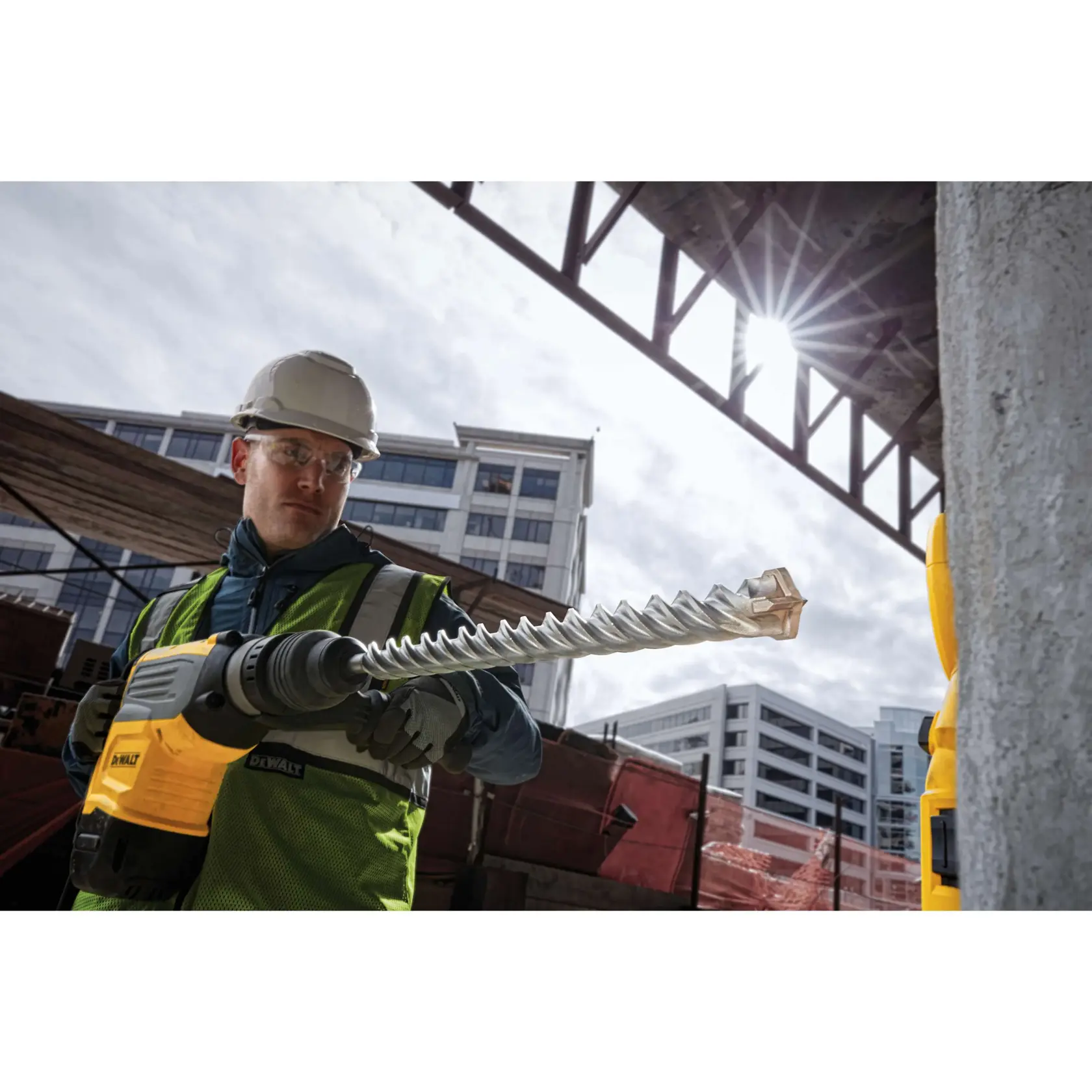 1 and 9 sixteenths inch by 18 inch by 22 and half inch S D S Max High Impact Carbide 4 Cutter Drill Bit being held by worker ready to be used on wall.