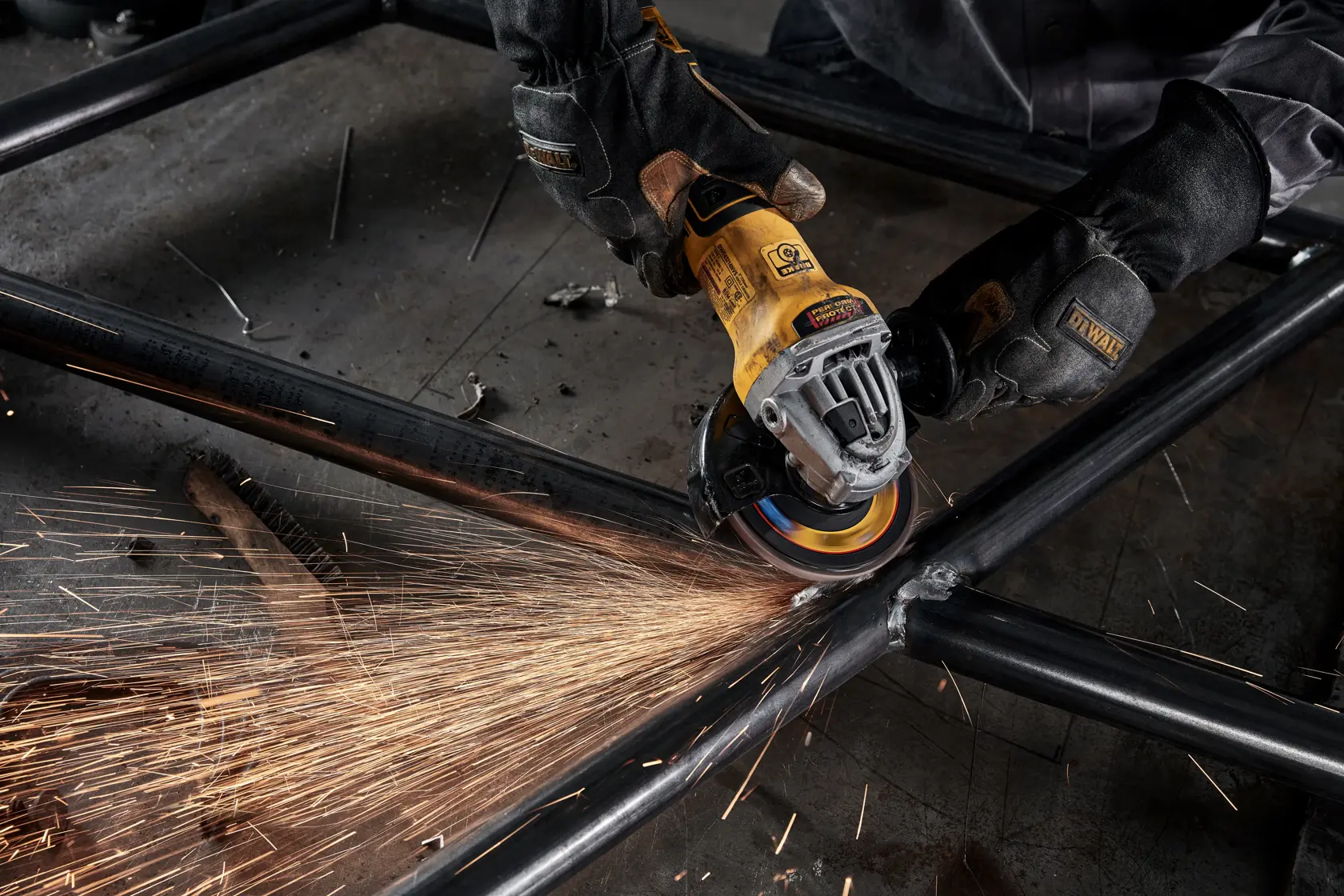 Person using DEWALT ELITE SERIES flap discs to clean up welds of pipes