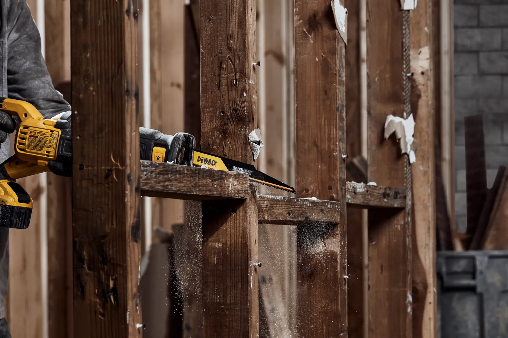 Person using ELITE SERIES Carbide Tipped Reciprocating Blade to cut wood frame