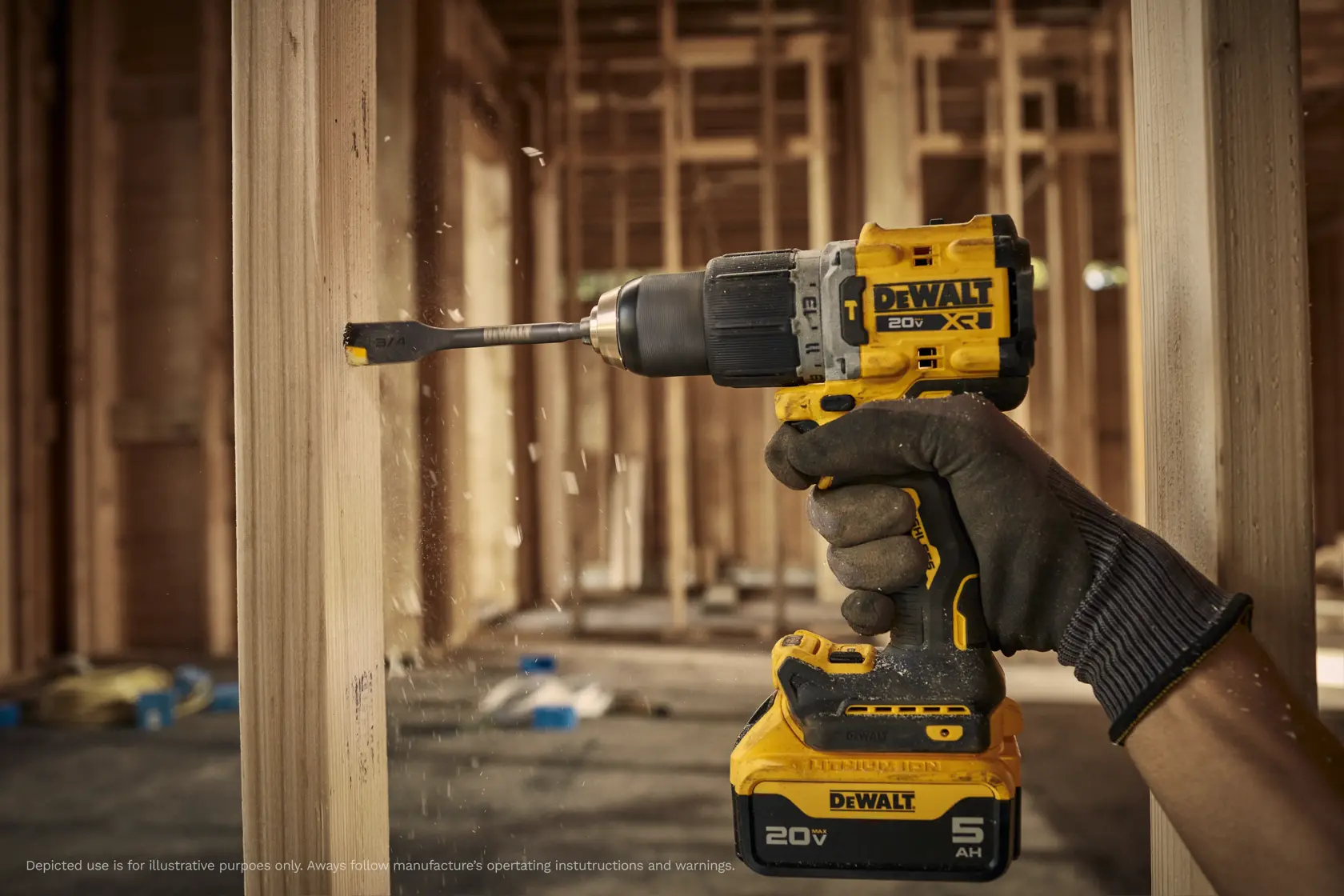 A gloved hand operating a yellow DEWALT cordless power drill with a spade bit, drilling into a wooden beam in a construction site with wooden framing visible in the background.