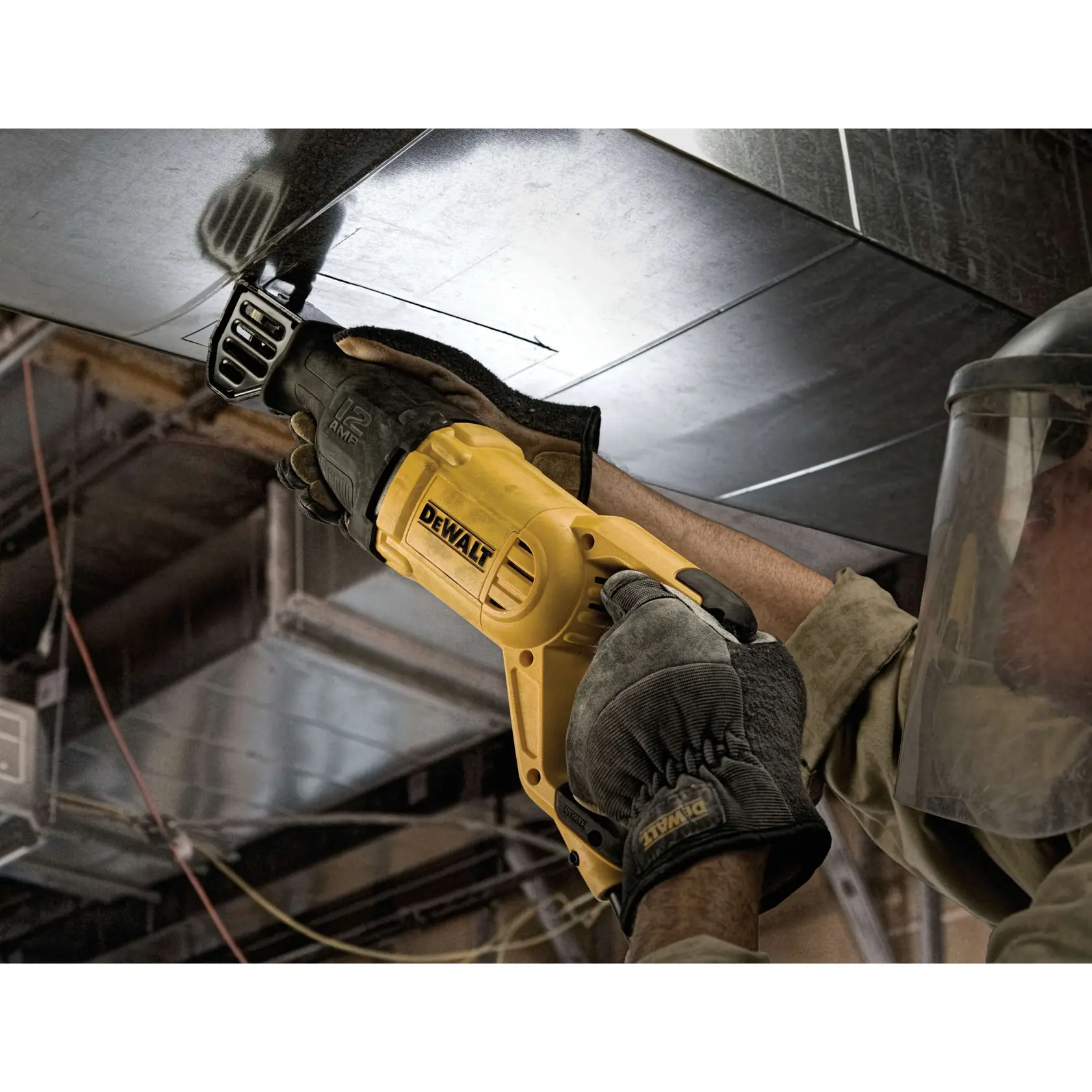 A person wearing protective gloves and a face shield is using a yellow DEWALT reciprocating saw (model DWE305) to cut a metal duct in an industrial setting.