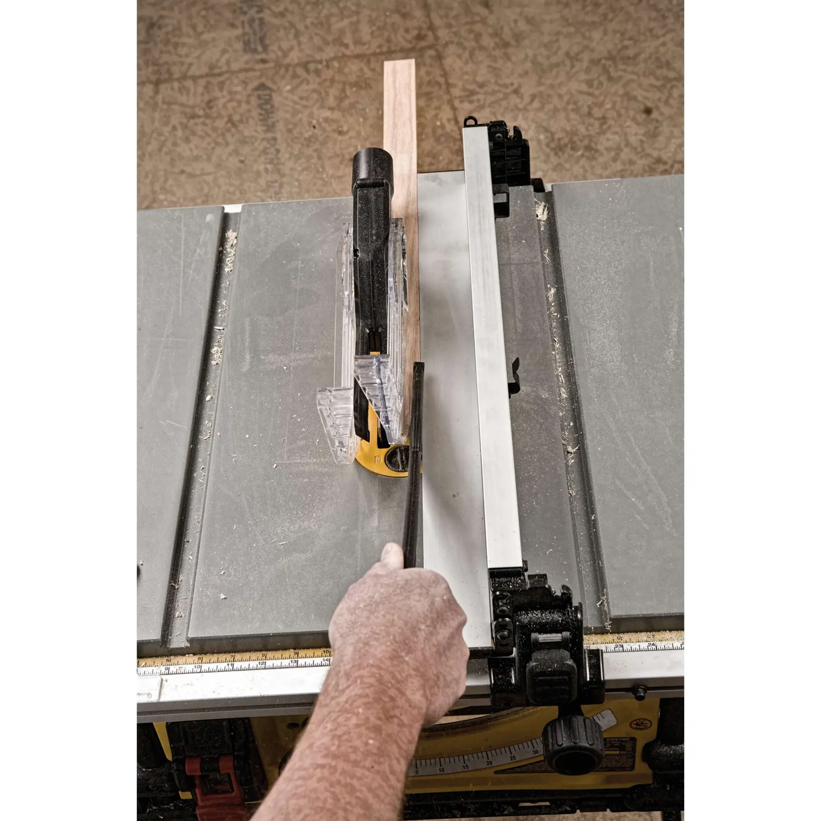 Table saw with scissor stand cross cutting wooden plank.