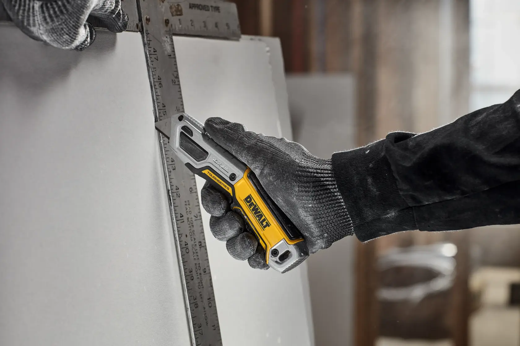 Worker cutting drywall with DEWALT® TOUGHSERIES™ DWHT10999 Utility Knife