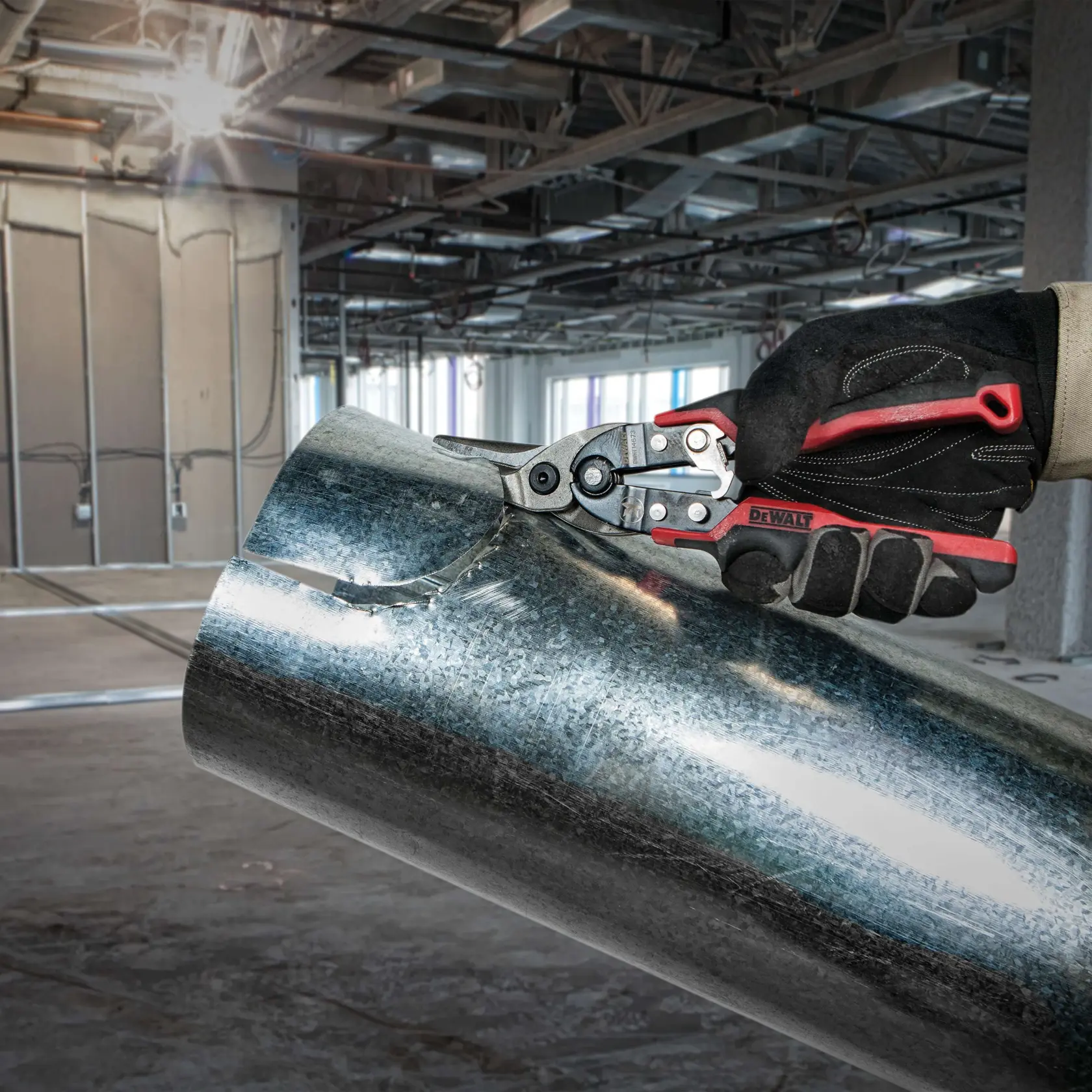 Left Cut Ergo Aviation Snip being used to cut sheet metal pipe at worksite.