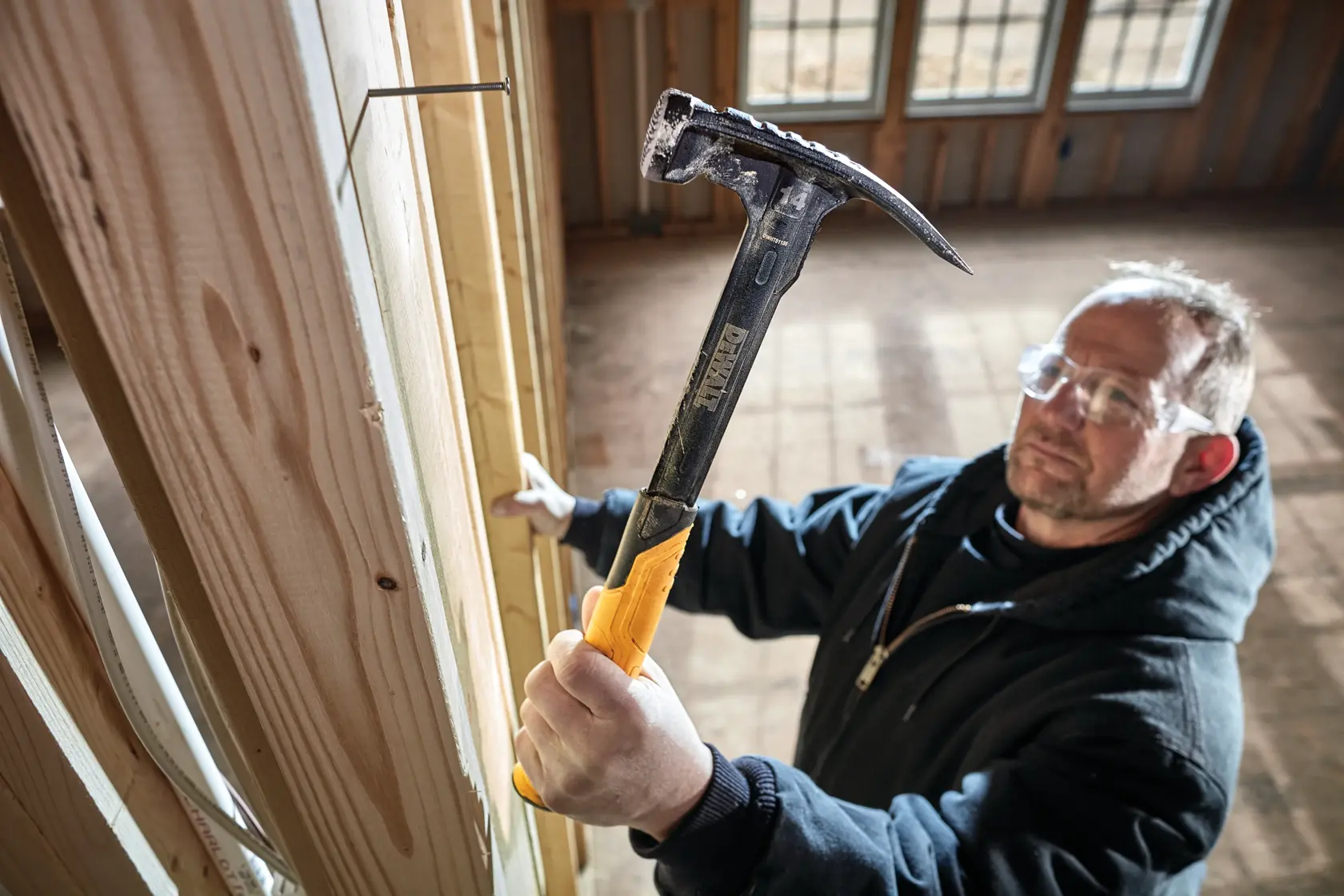 XP 1 Piece Steel 14 ounce MIG Weld Framing Hammer being used by a person on nail in wood.