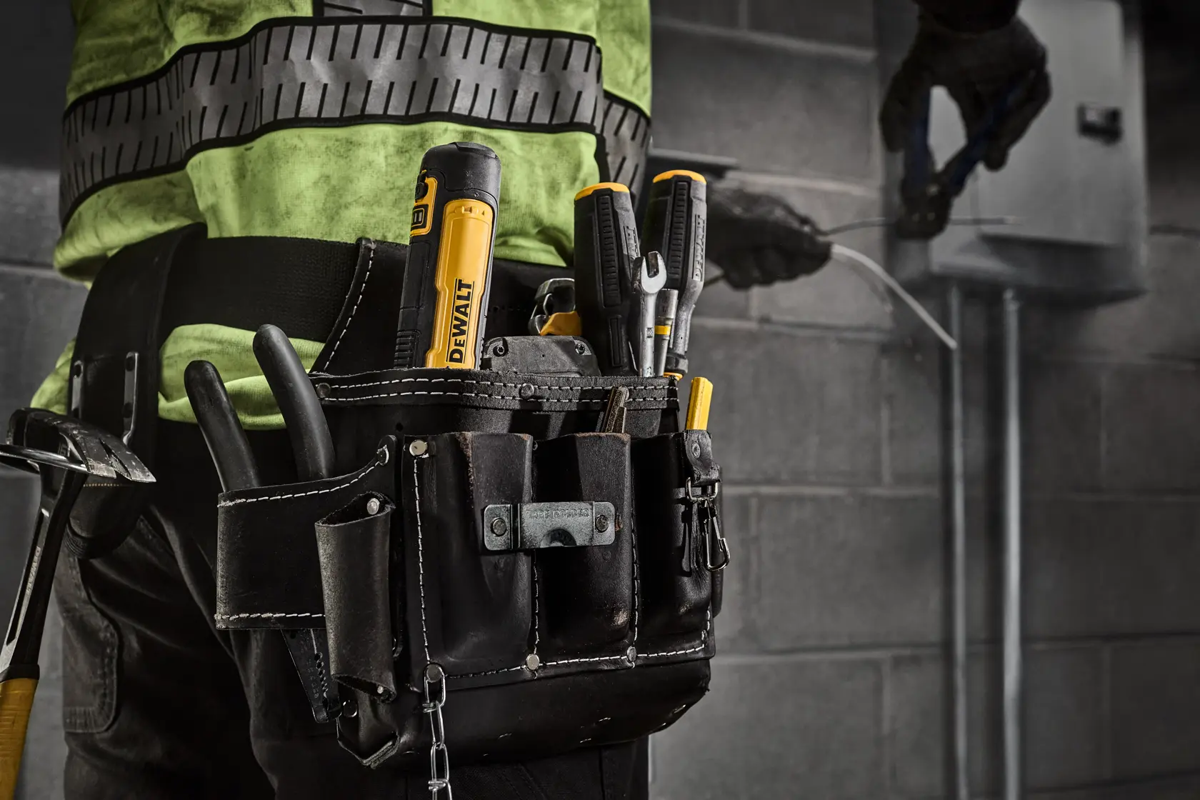DEWALT 4V USB Screwdriver protruding from a workers tool belt on a commercial jobsite