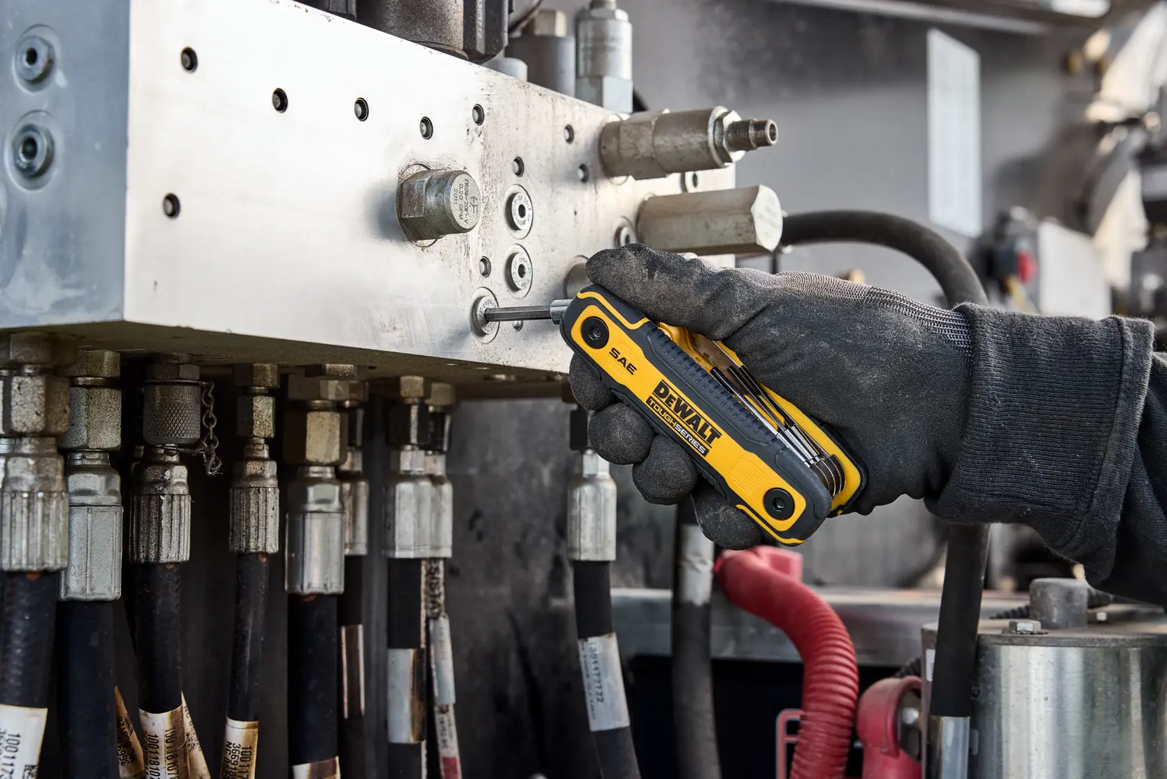 User tightening fastener on heavy machinery with the DEWALT TOUGHSERIES SAE Folding Locking Hex Key