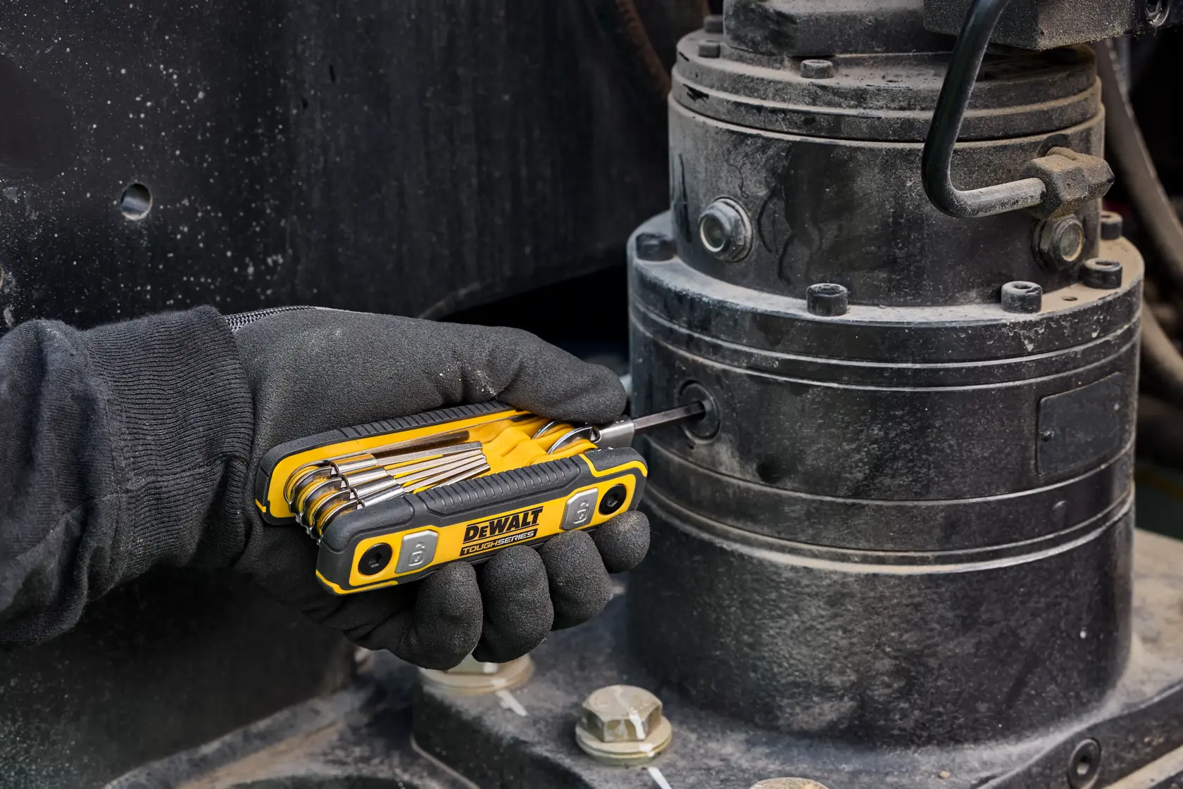 User tightening fastener on heavy machinery with the DEWALT TOUGHSERIES SAE Folding Locking Hex Key