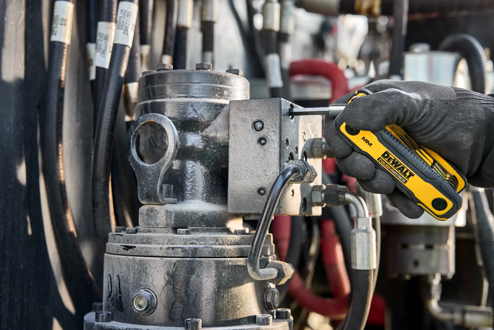 User tightening fastener on heavy machinery with the DEWALT TOUGHSERIES MM Folding Locking Hex Key