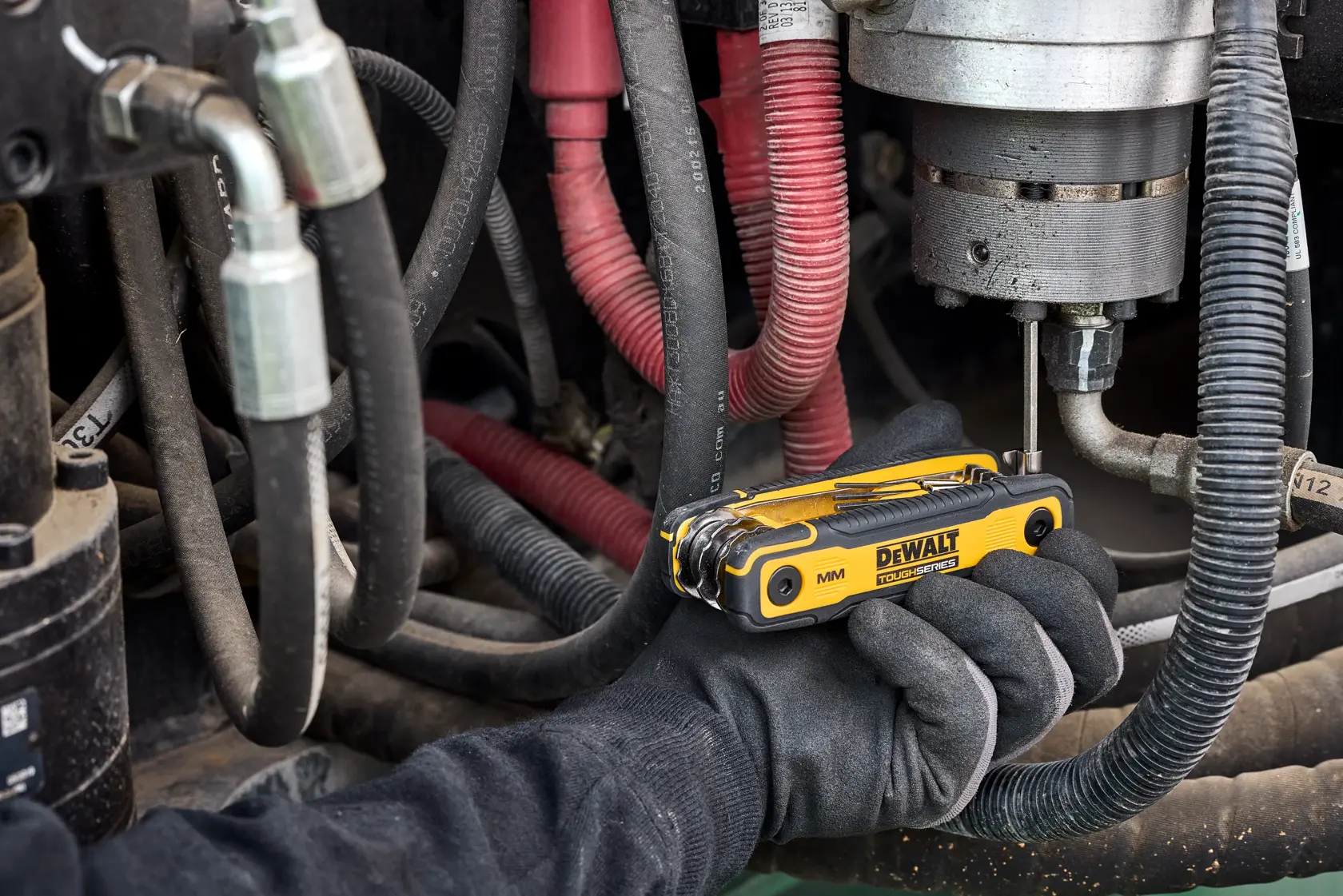 User tightening fastener on heavy machinery with the DEWALT TOUGHSERIES MM Folding Locking Hex Key