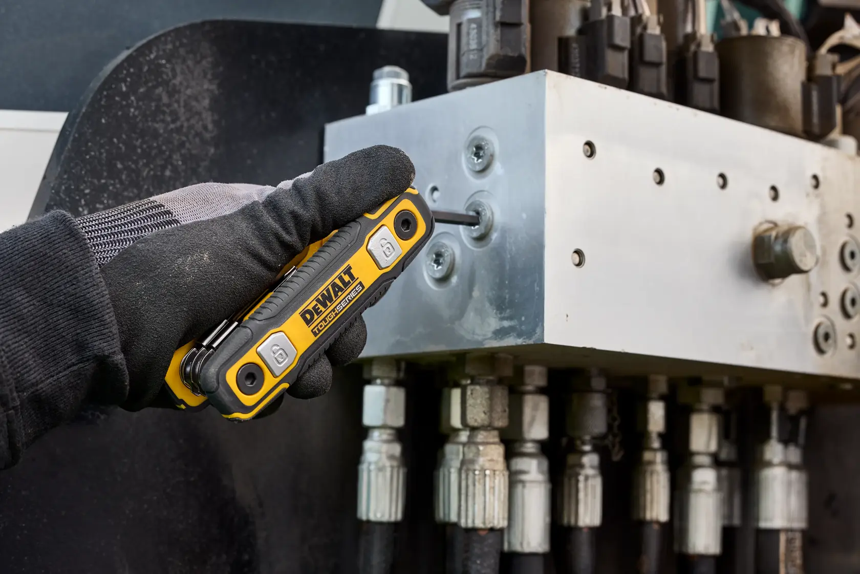 User tightening fastener on heavy machinery with the DEWALT TOUGHSERIES  Folding Locking Hex Key
