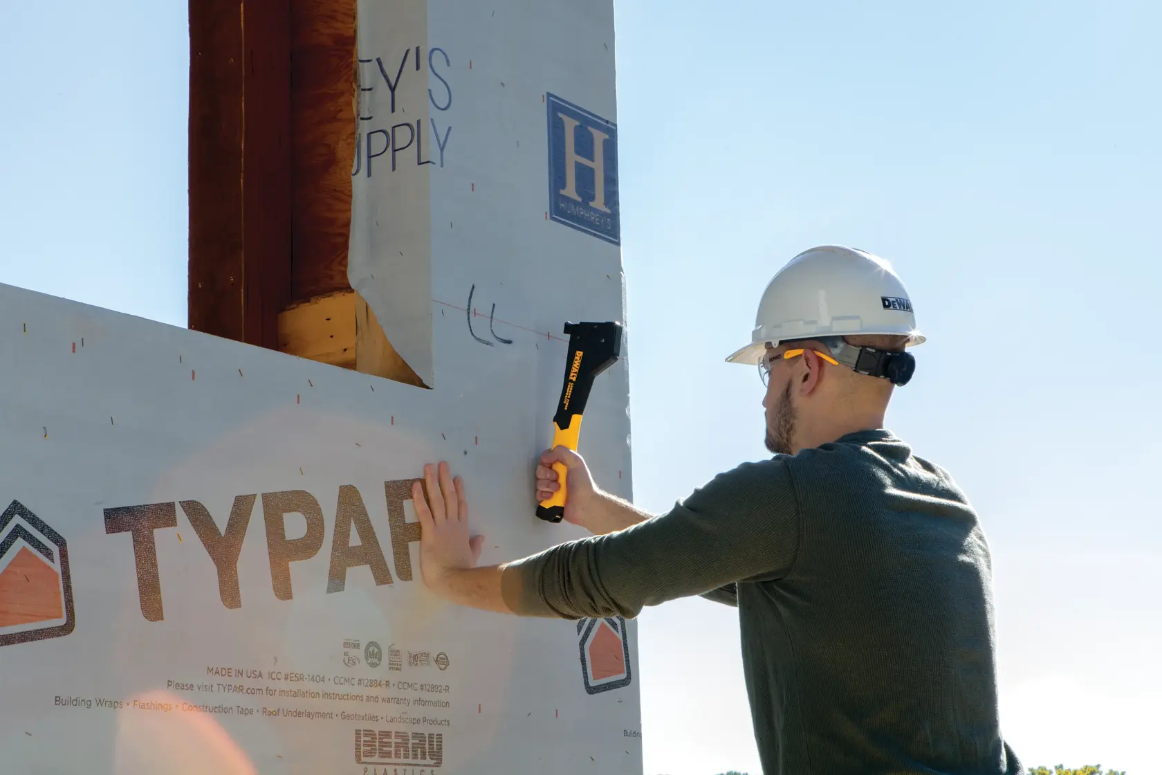 Carbon Fiber Composite Hammer Tacker being used on a sructure by a construction worker.