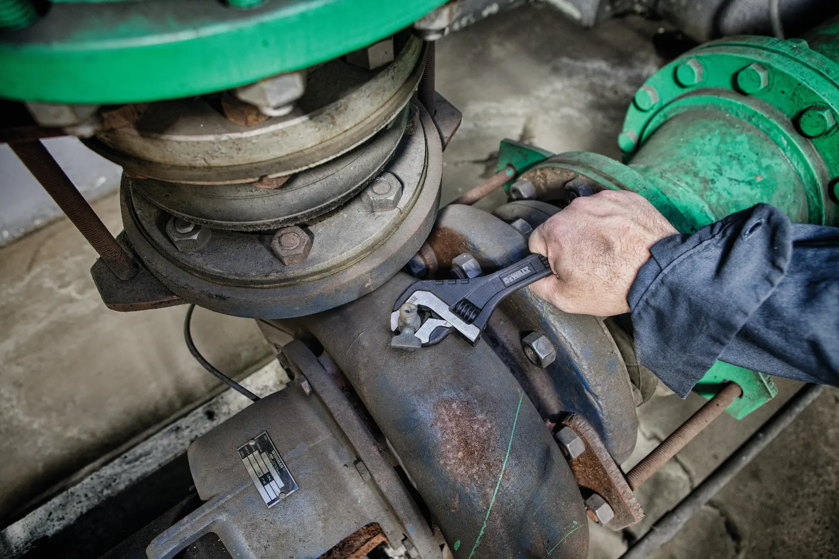 top view of  8 inch All Steel Adjustable Wrench being used to adjust screws on a machine.