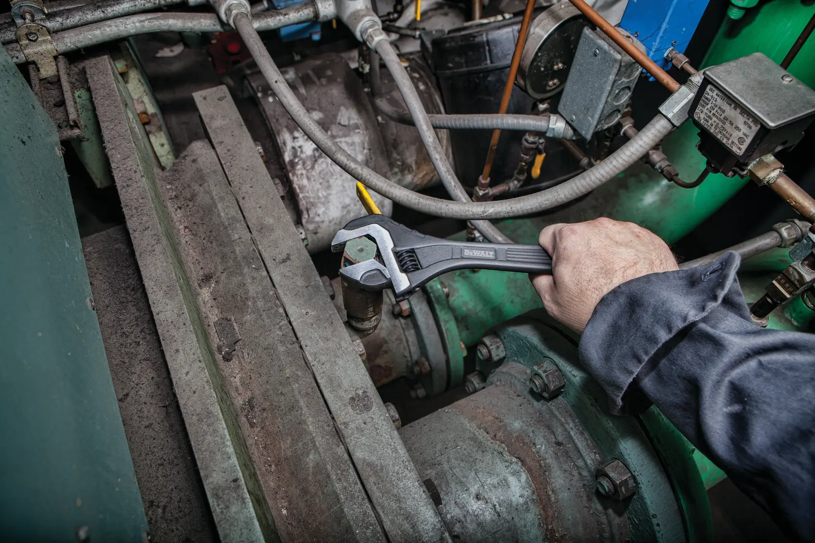 12 inch All Steel Adjustable Wrench being used to adjust bolts on a machine.