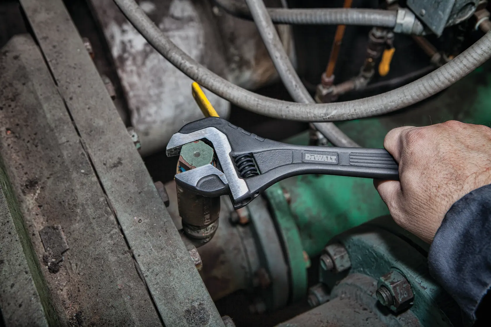 Close up of  12 inch All Steel Adjustable Wrench being used to adjust bolts on a machine.