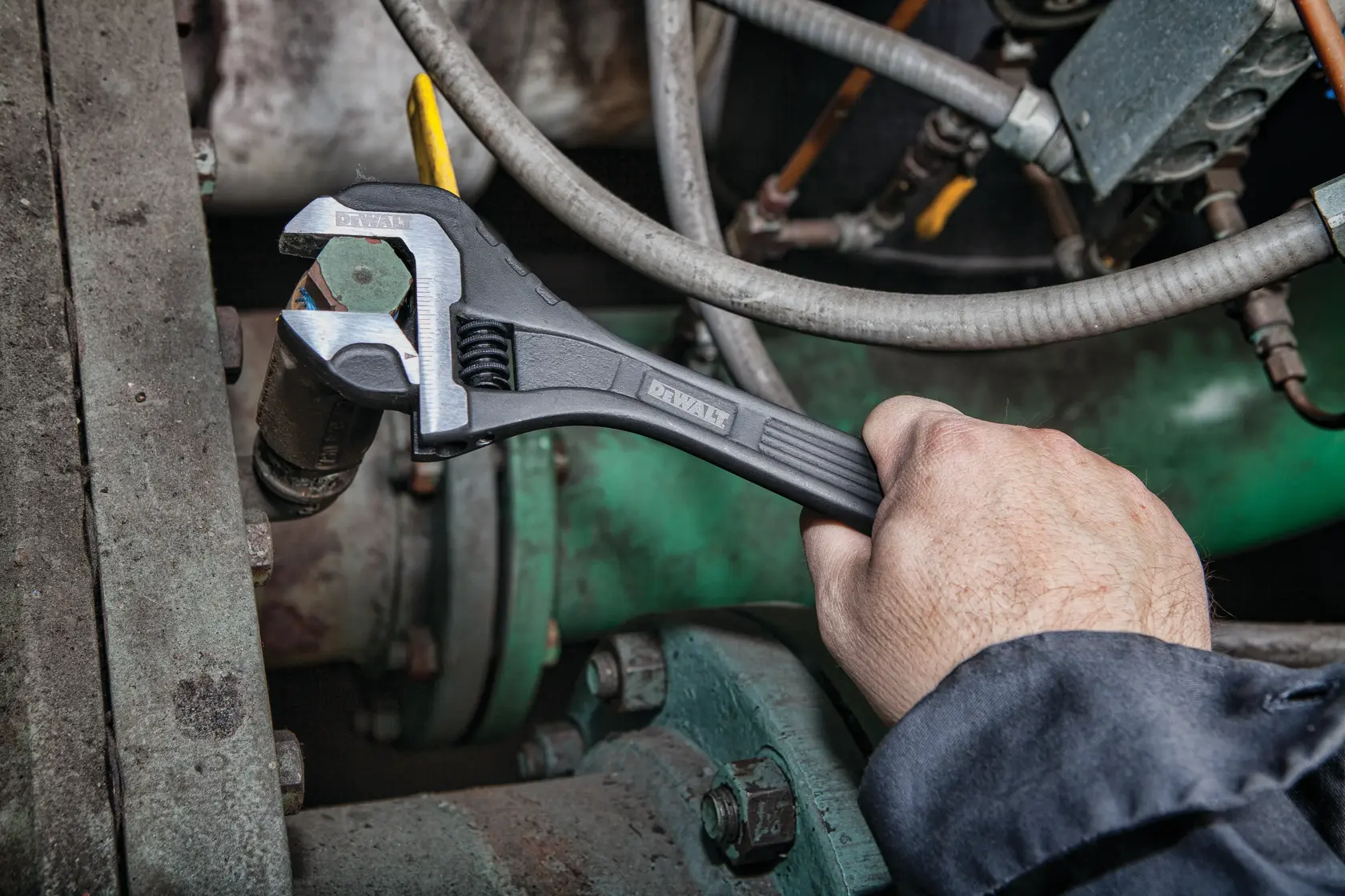 Close up of  12 inch All Steel Adjustable Wrench being used to adjust bolts on a machine.