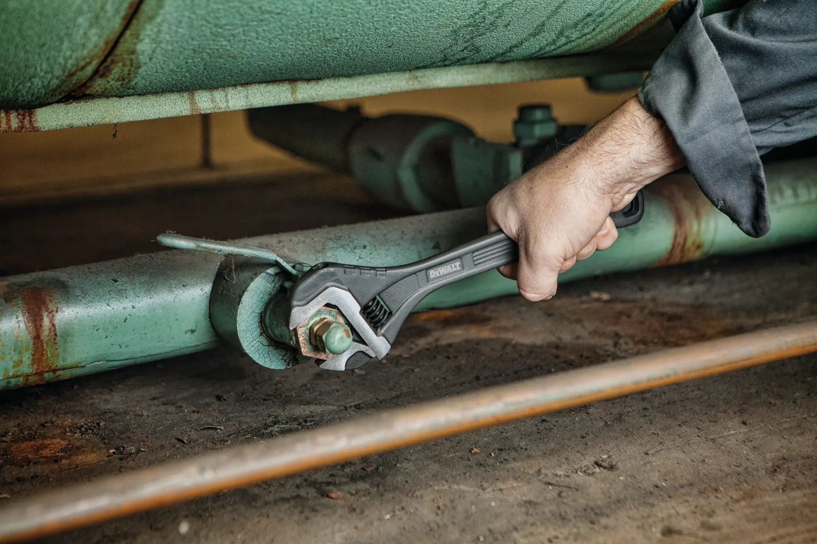 12 inch All Steel Adjustable Wrench being used to adjust bolts on a machine.