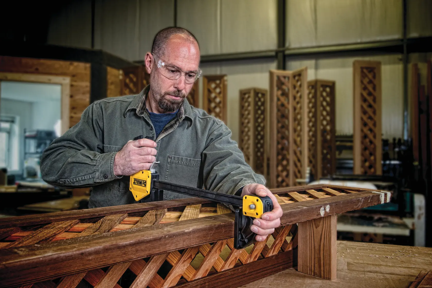 24 inch Extra Large Trigger Clamp being used on wooden structures by a person in a workshop.