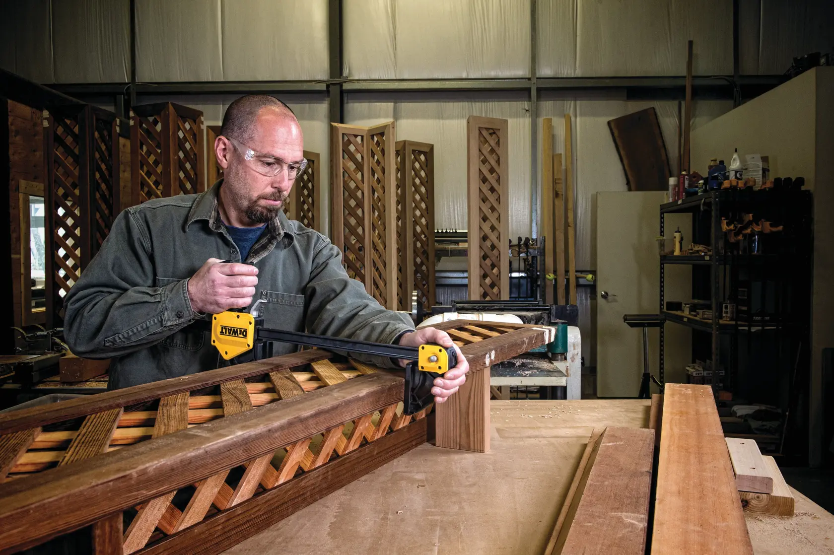 24 inch Extra Large Trigger Clamp being used on wooden structures by a person in a workshop.