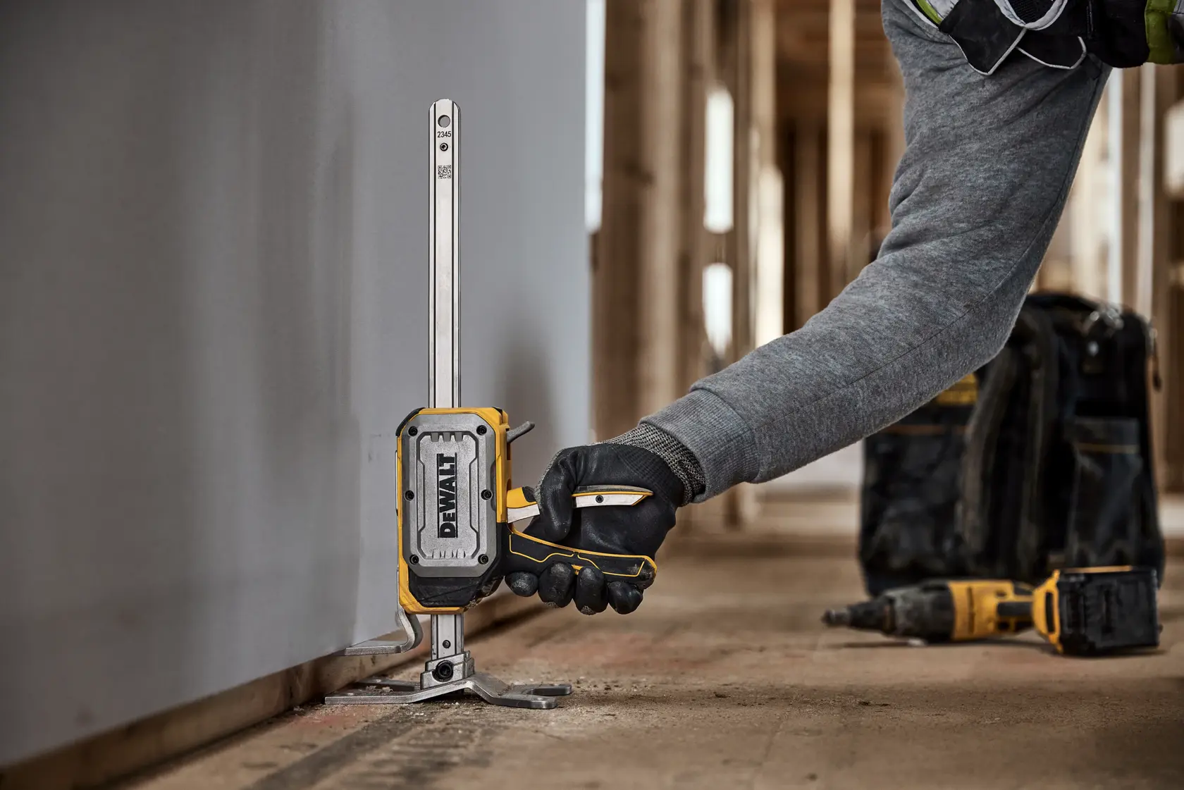 Worker lifting drywall with DEWALT(R) TOUGHSERIES(TM) CONSTRUCTION JACK 