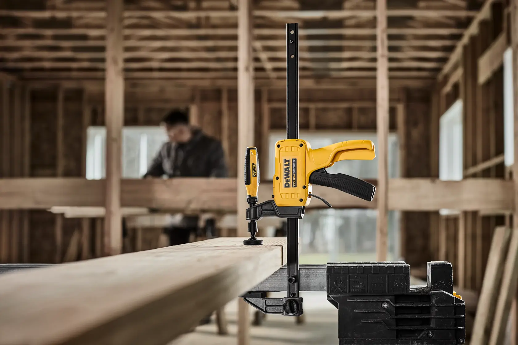 DEWALT 12“ Large Hybrid Clamp securing a piece of wood to a sawhorse