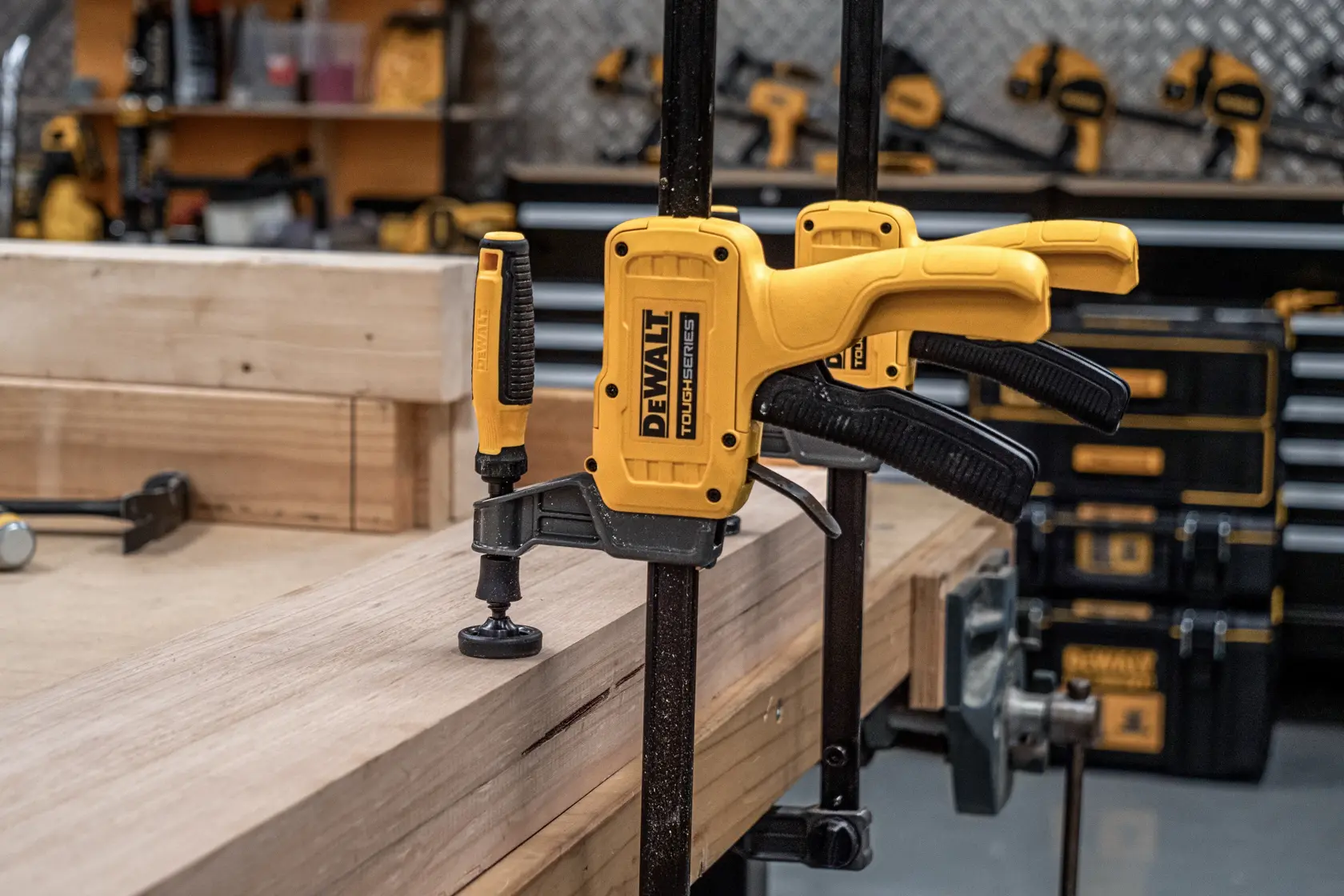 Two DEWALT 24“ Hybrid Clamps securing piece of wood to work top