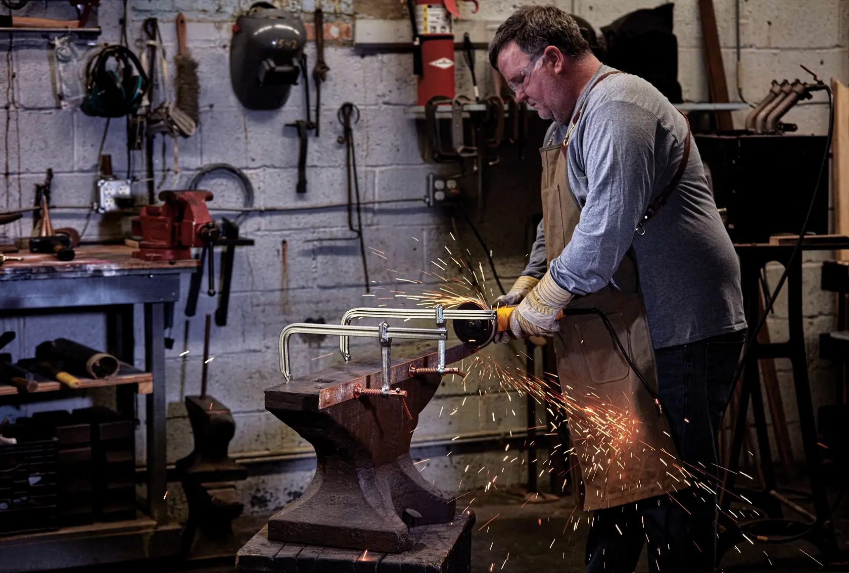 12 inch Metalworking bar Clamp being used by a person in a workshop.