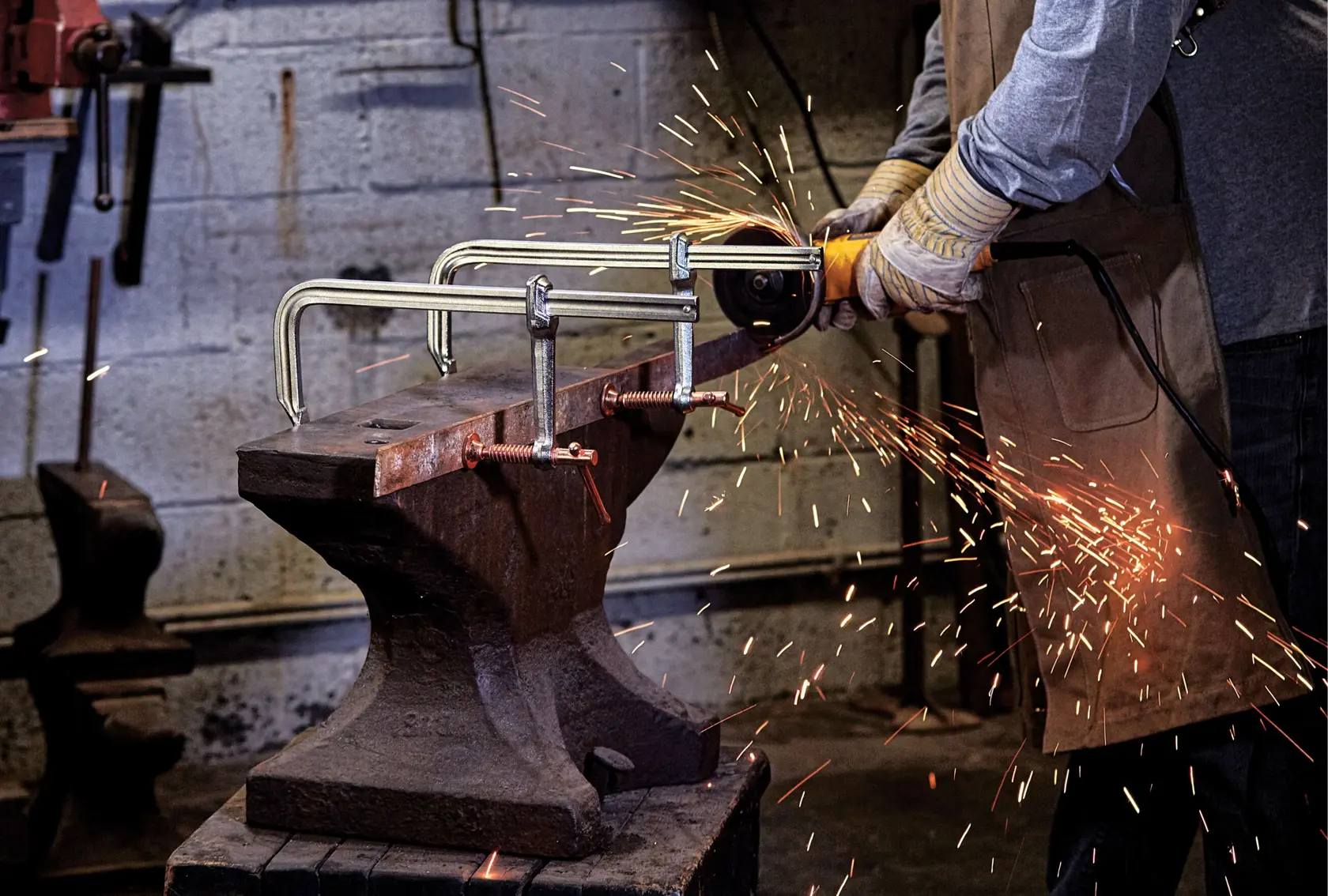 12 inch Metalworking bar Clamp being used by a person in a workshop.