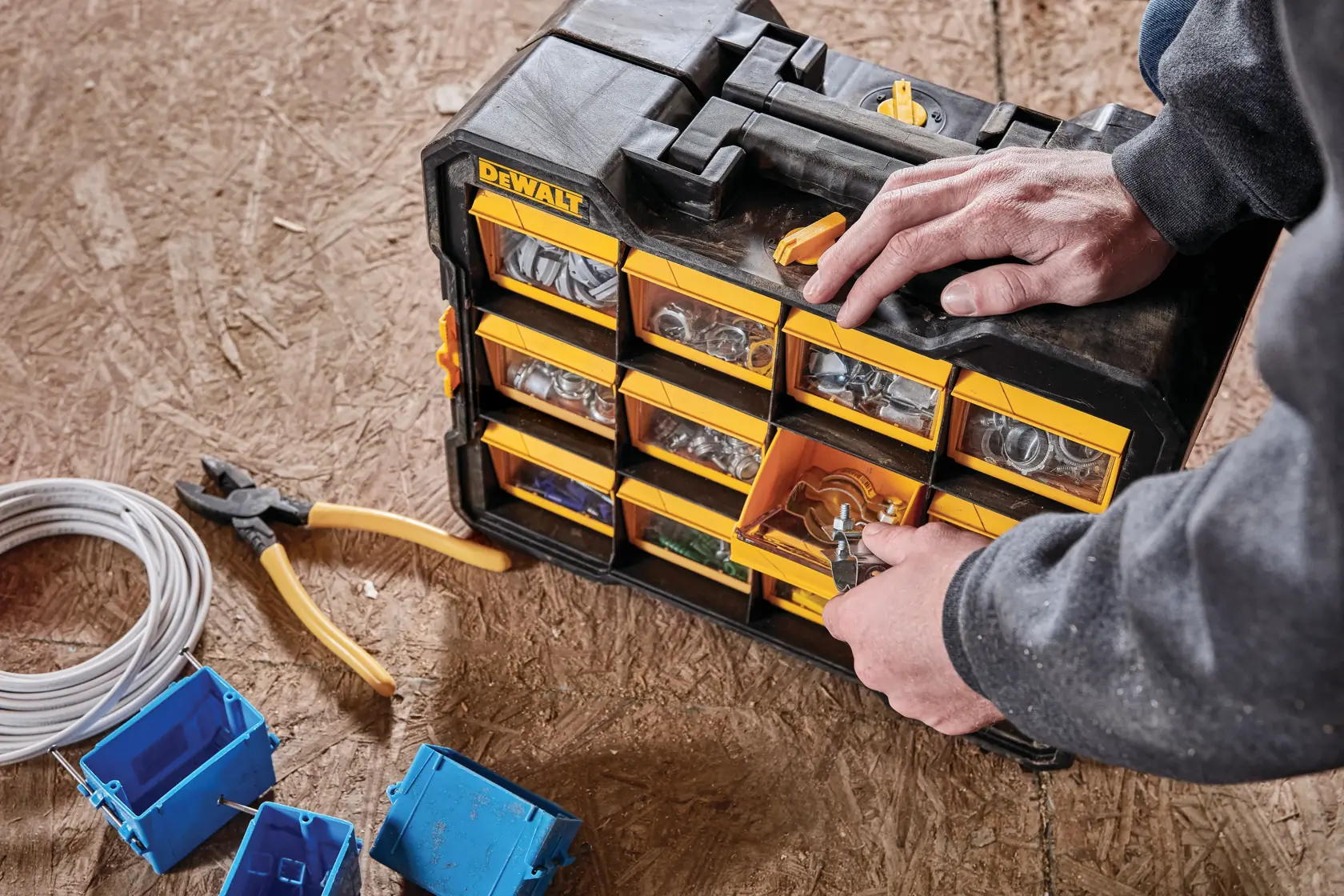 Flip bin organizer holding small parts that are being retrieved for use.