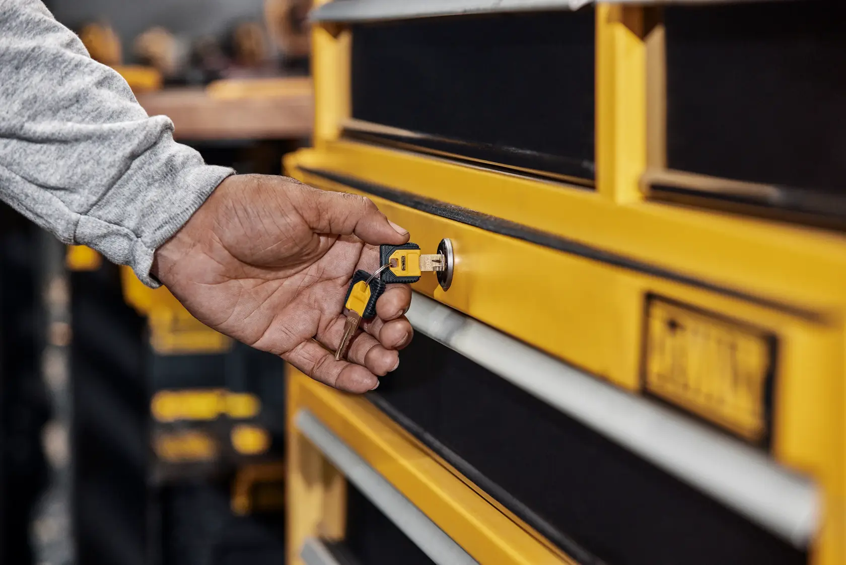 A Person Turning a Key In A DEWALT Cabinet