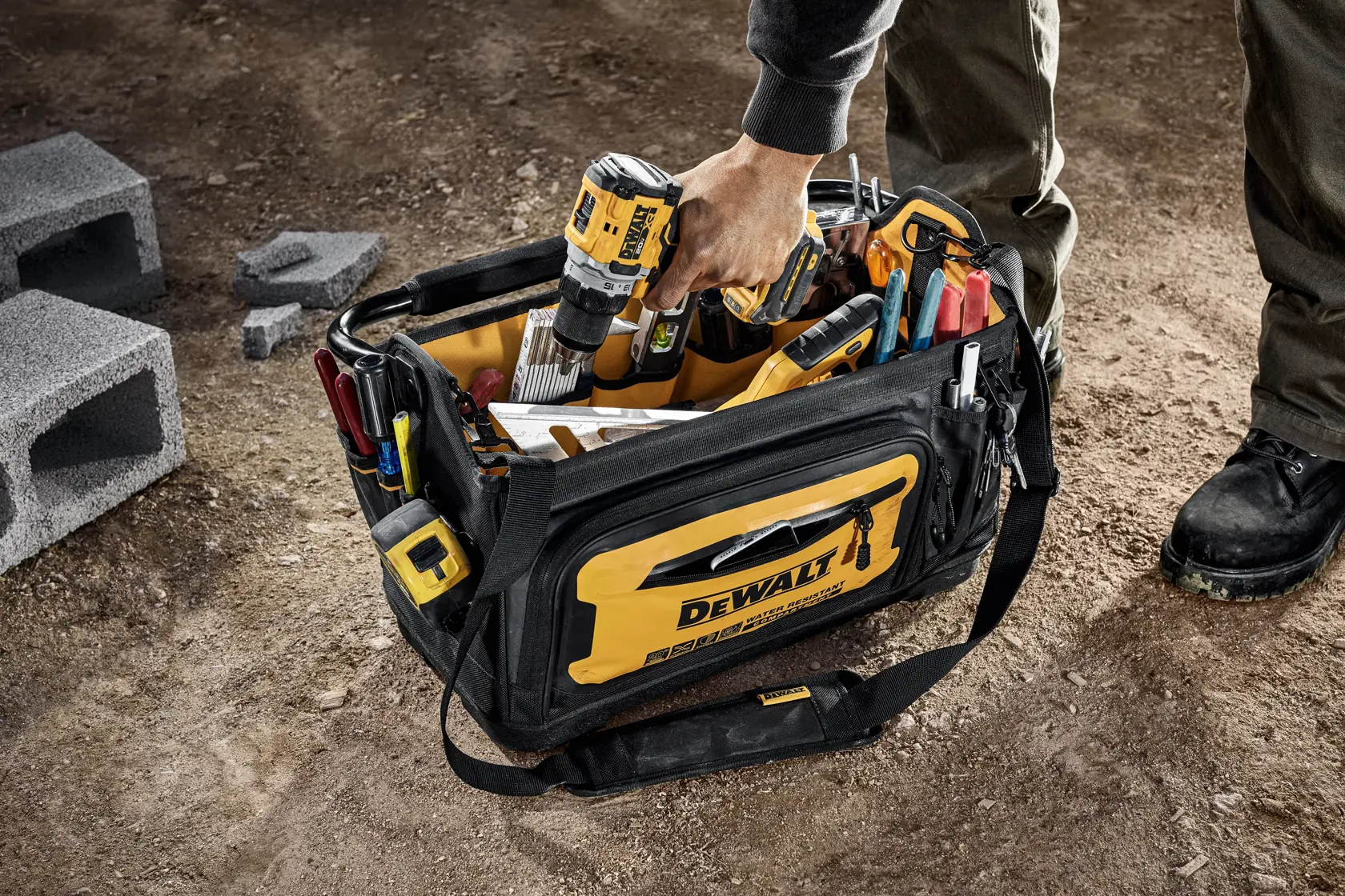 WORKER LIFTING DRILL OUT OF DEWALT 20 INCH PRO TOTE