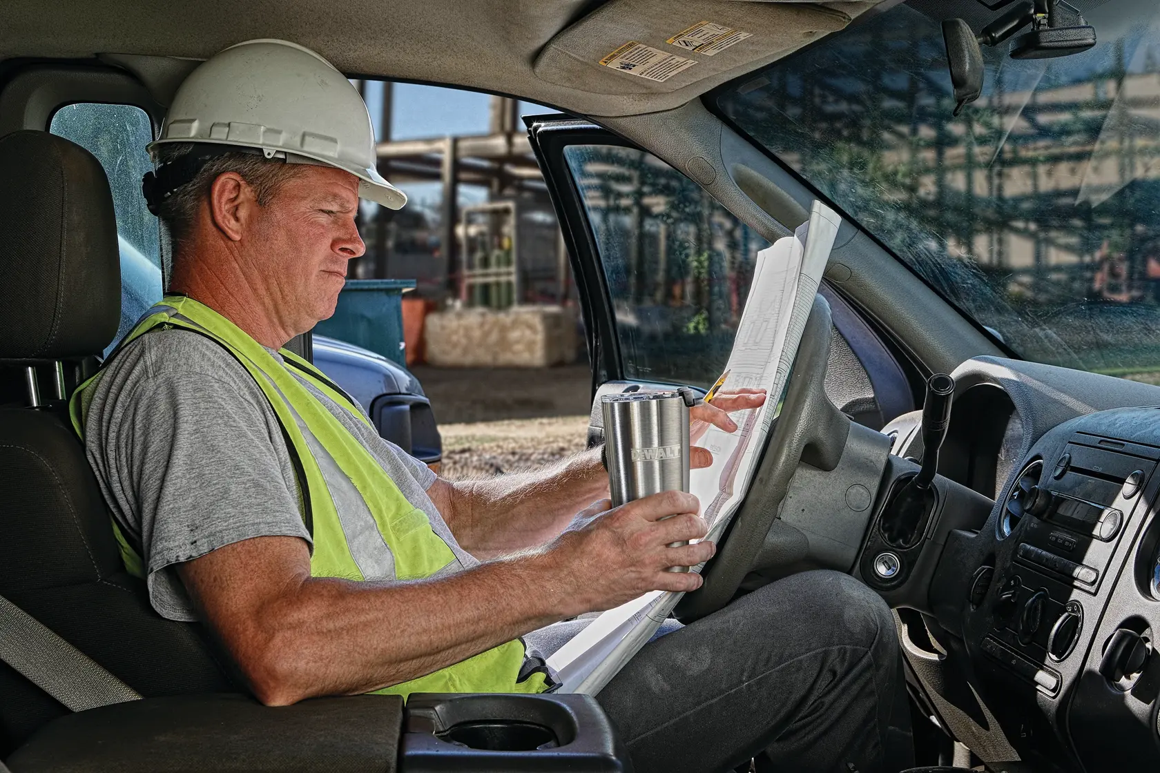 20 Ounce Stainless steel tumbler being used by a person on jobsite.n