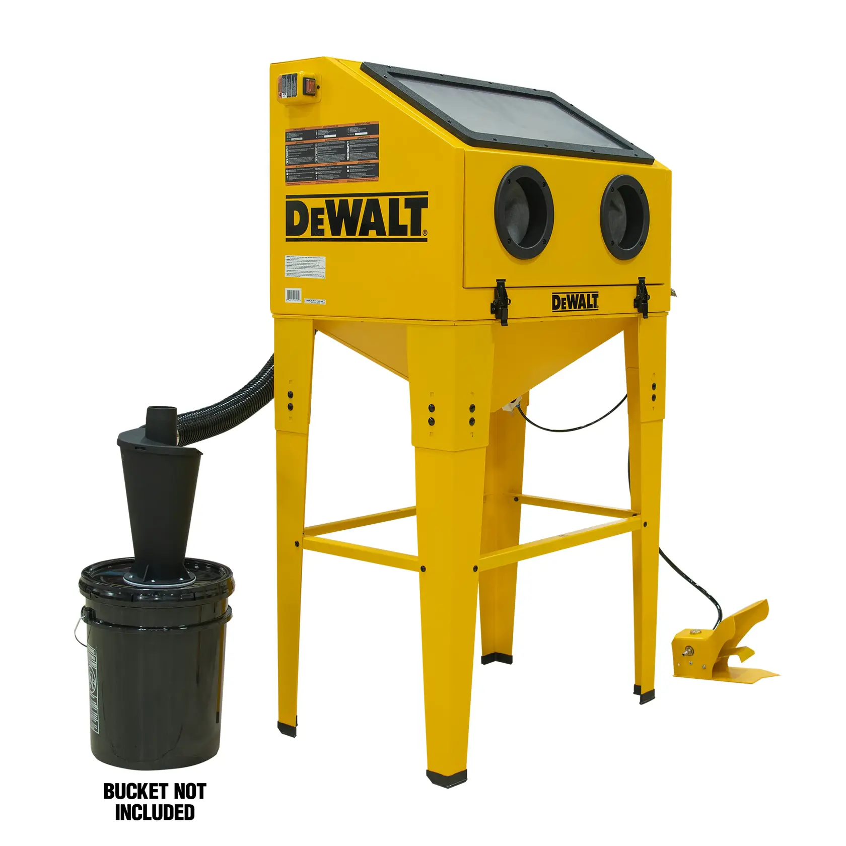 A yellow DEWALT sandblasting cabinet with a transparent top viewing window, two glove ports, and tall supporting legs. Attached to the cabinet is a black hose leading to a funnel placed in a black bucket, which is labeled as not included. A yellow foot pedal is on the floor, used to operate the cabinet.