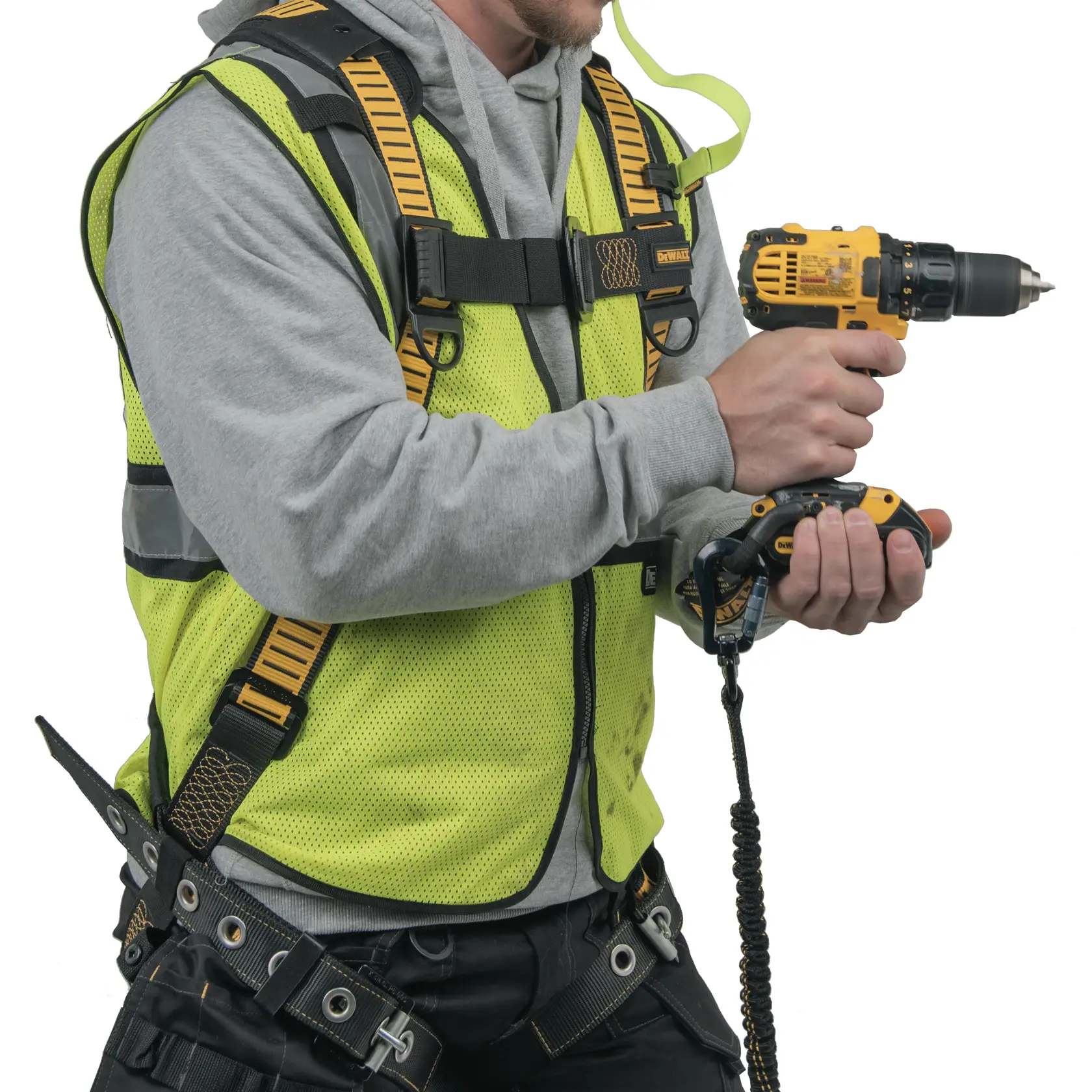 A person wearing a high-visibility safety vest and harness is holding a yellow DEWALT power drill with a safety tether attached.