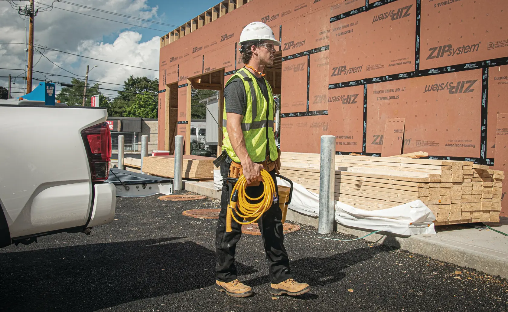50 feet twelve thirds Lighted Locking C G M Extension Cord being carried by worker at worksite.