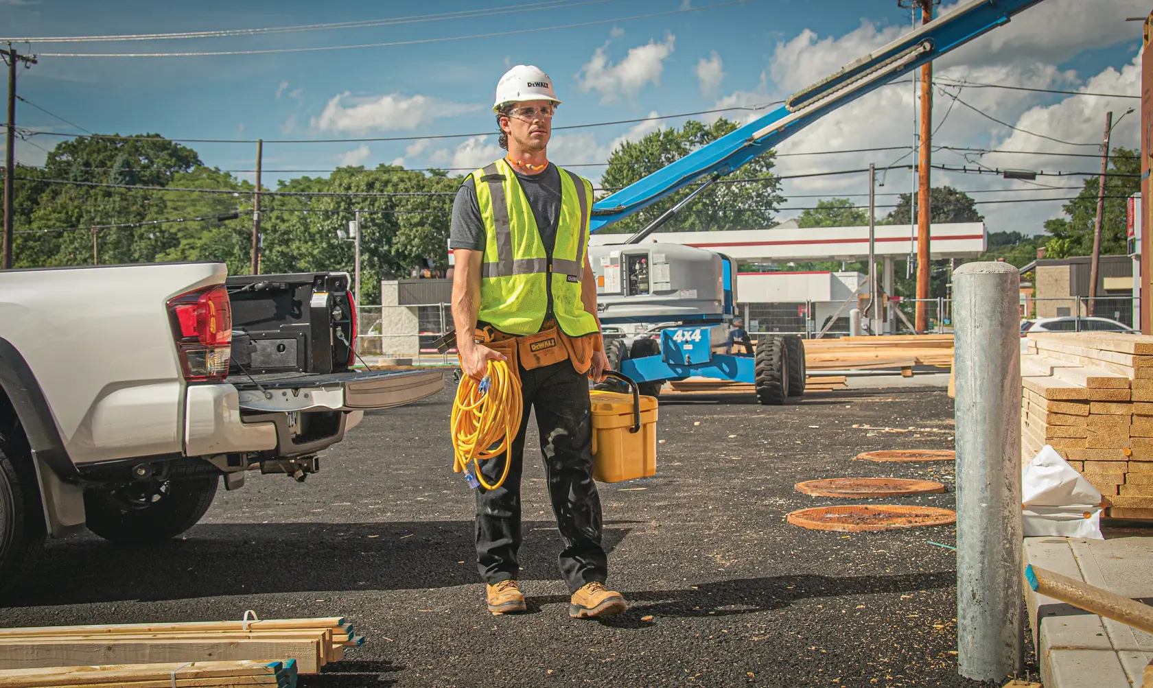 100 feet ten thirds Lighted C G M Extension Cord being carried by worker at worksite.
