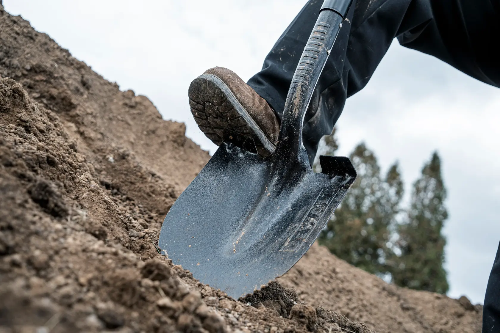 49 inch Fiberglass Handle Digging Shovel close up being pushed into dirt in work boots