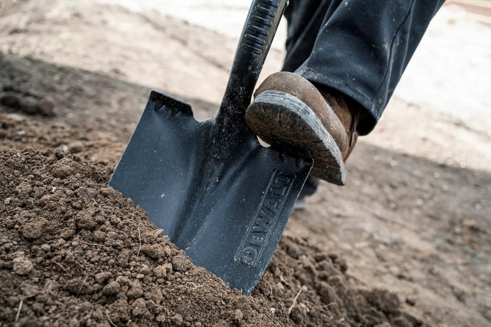 49 inch Wood Handle Digging Shovel close up being pushed into dirt in work boots