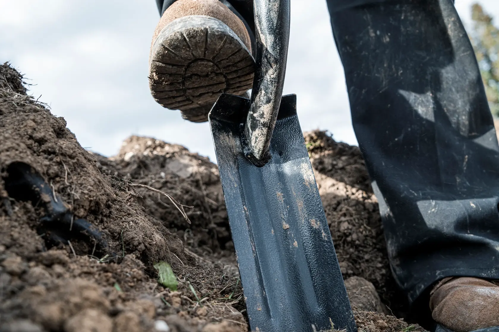 46 inch Wood Handle Trenching Shovel close up being pushed into dirt
