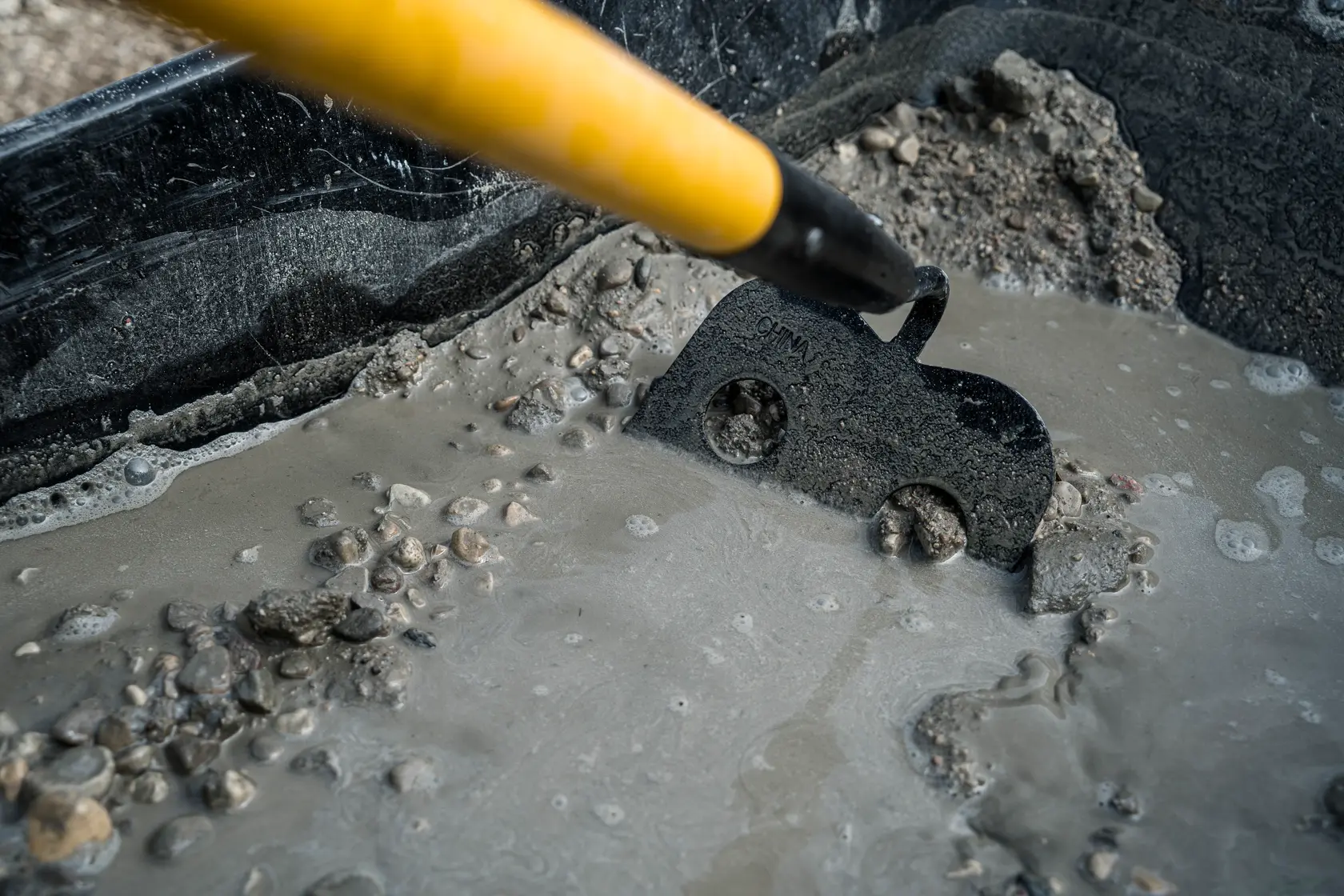 53 inch Fiberglass Handle Mortar Hoe close up spreading wet concrete