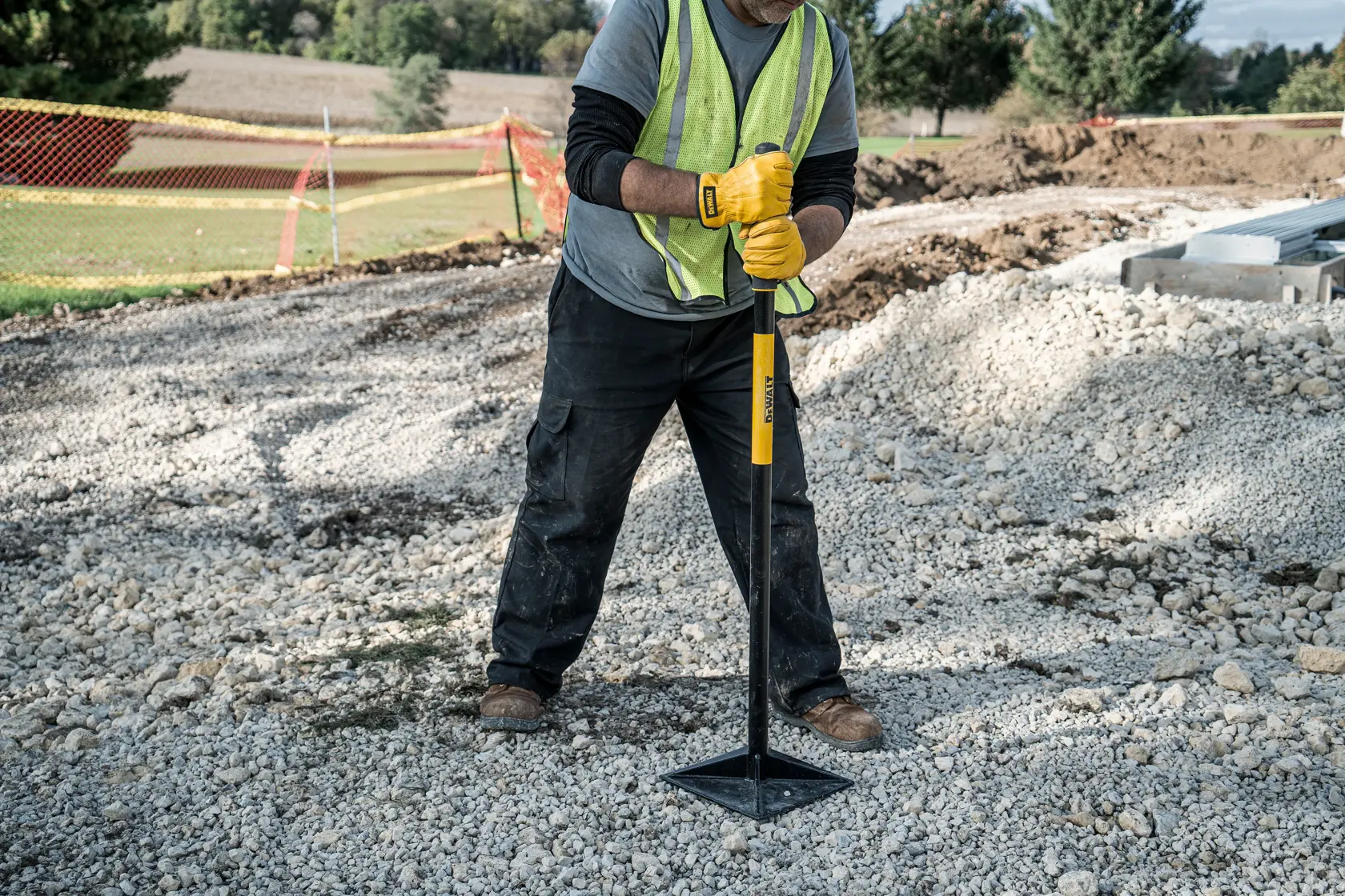 10 x 10 inch Steel Tamper in front view compacting gravel in gray shirt and safety vest