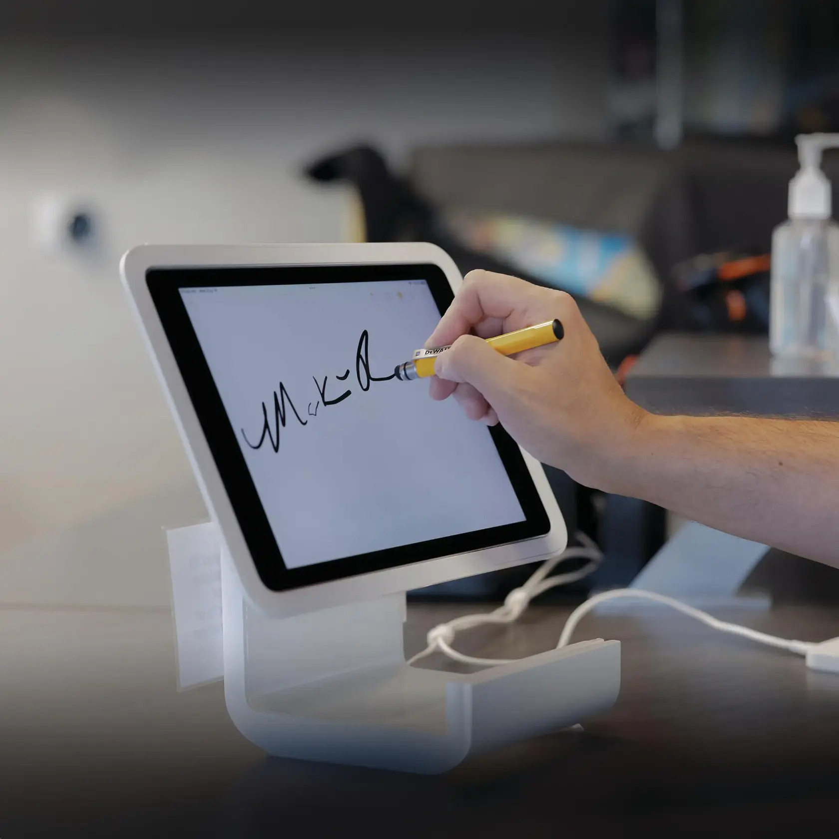 Stylus being used on a touchscreen tablet to sign off on a project.