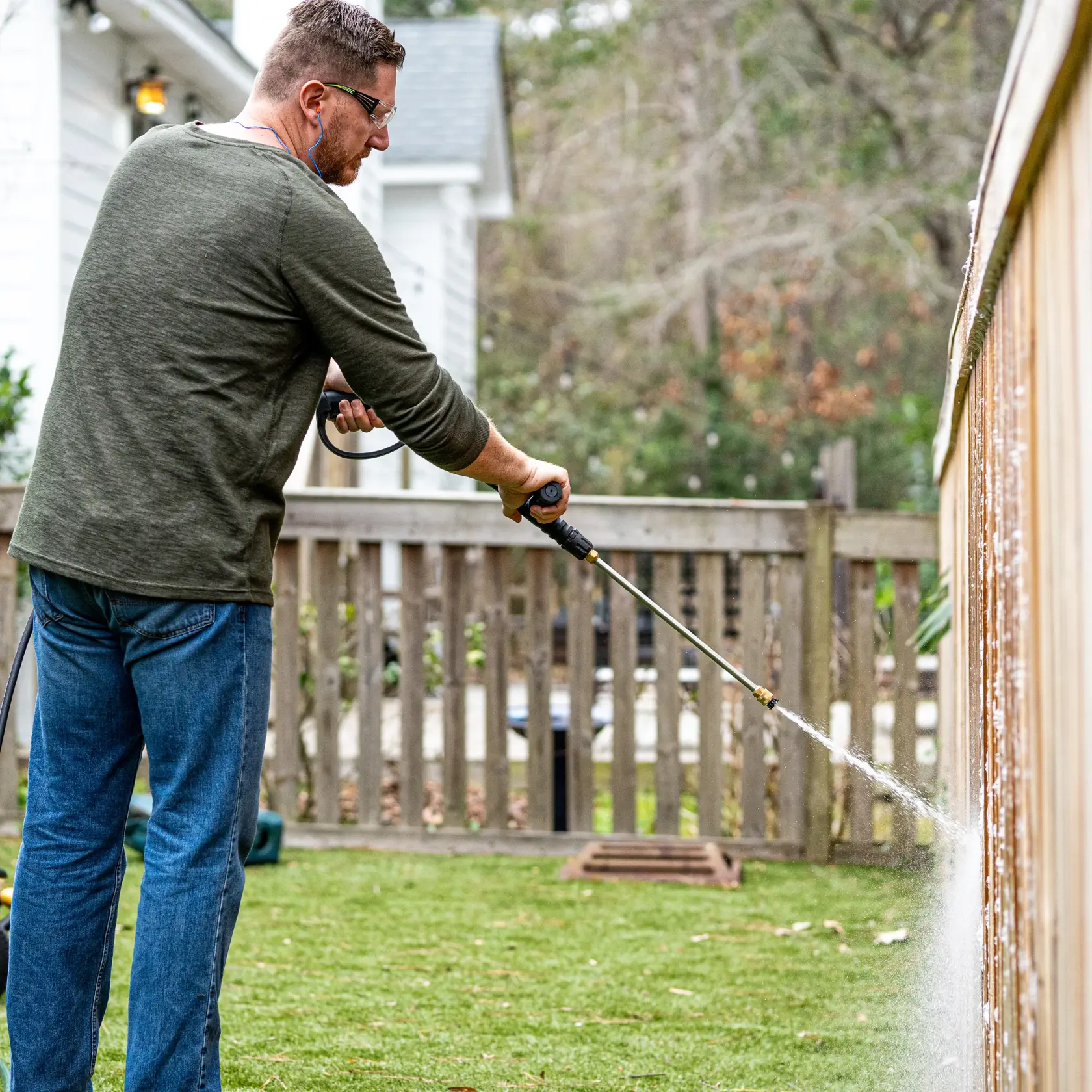 Pressure washing fence with soap nozzle