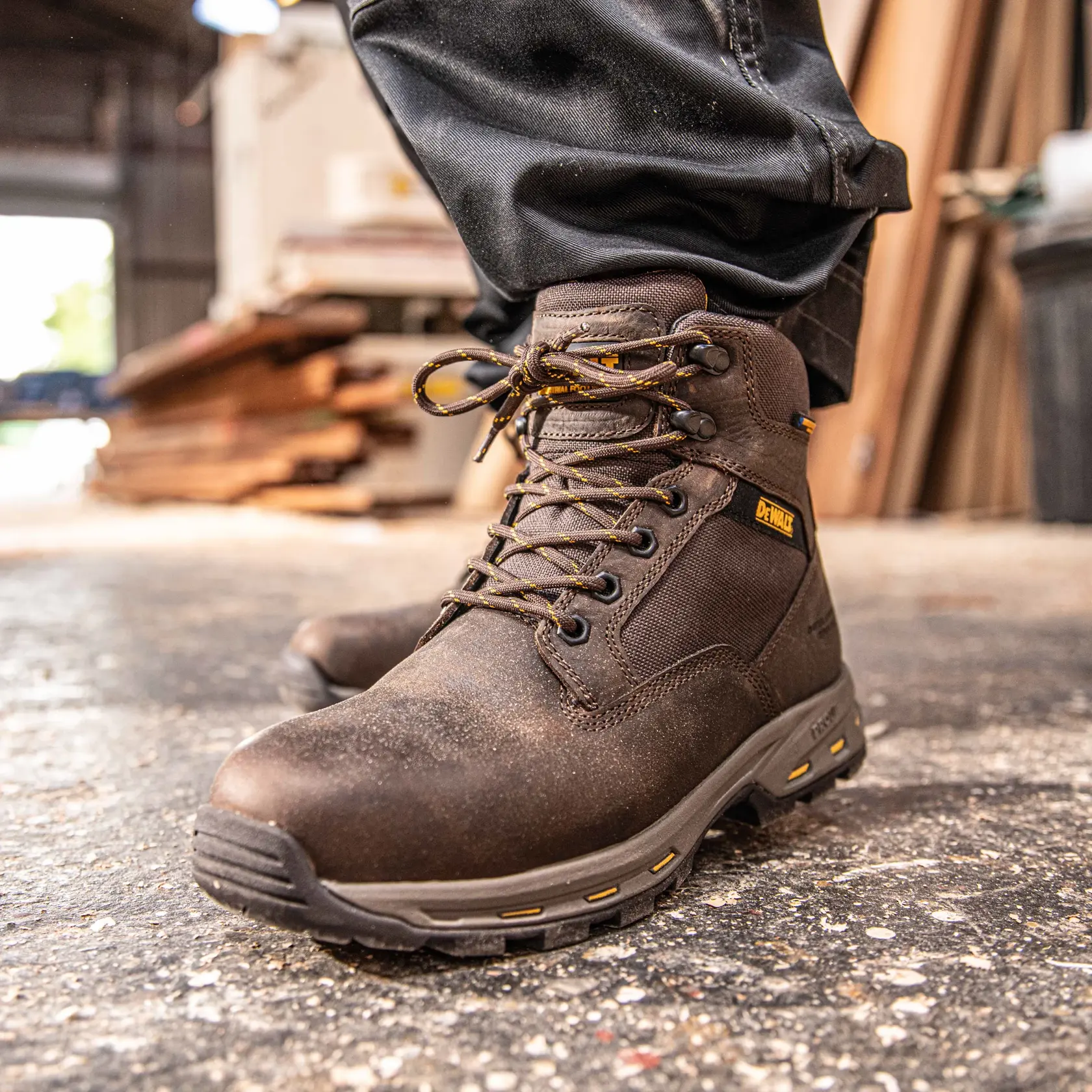 Front view facing left of the DEWALT Halogen Lite men’s safety boot in brown on model on location