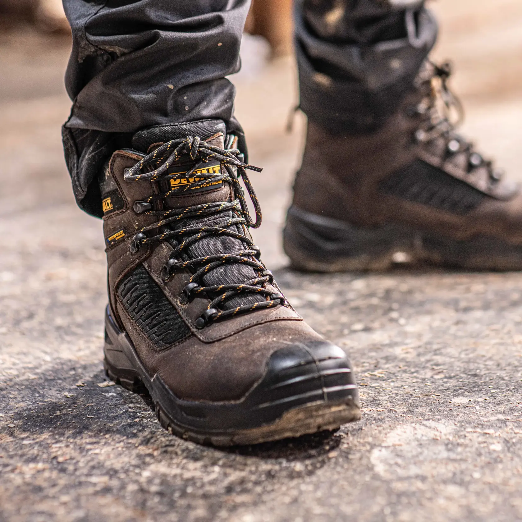 Front view facing right of the DEWALT Reynolds men’s safety boot in brown on model on location