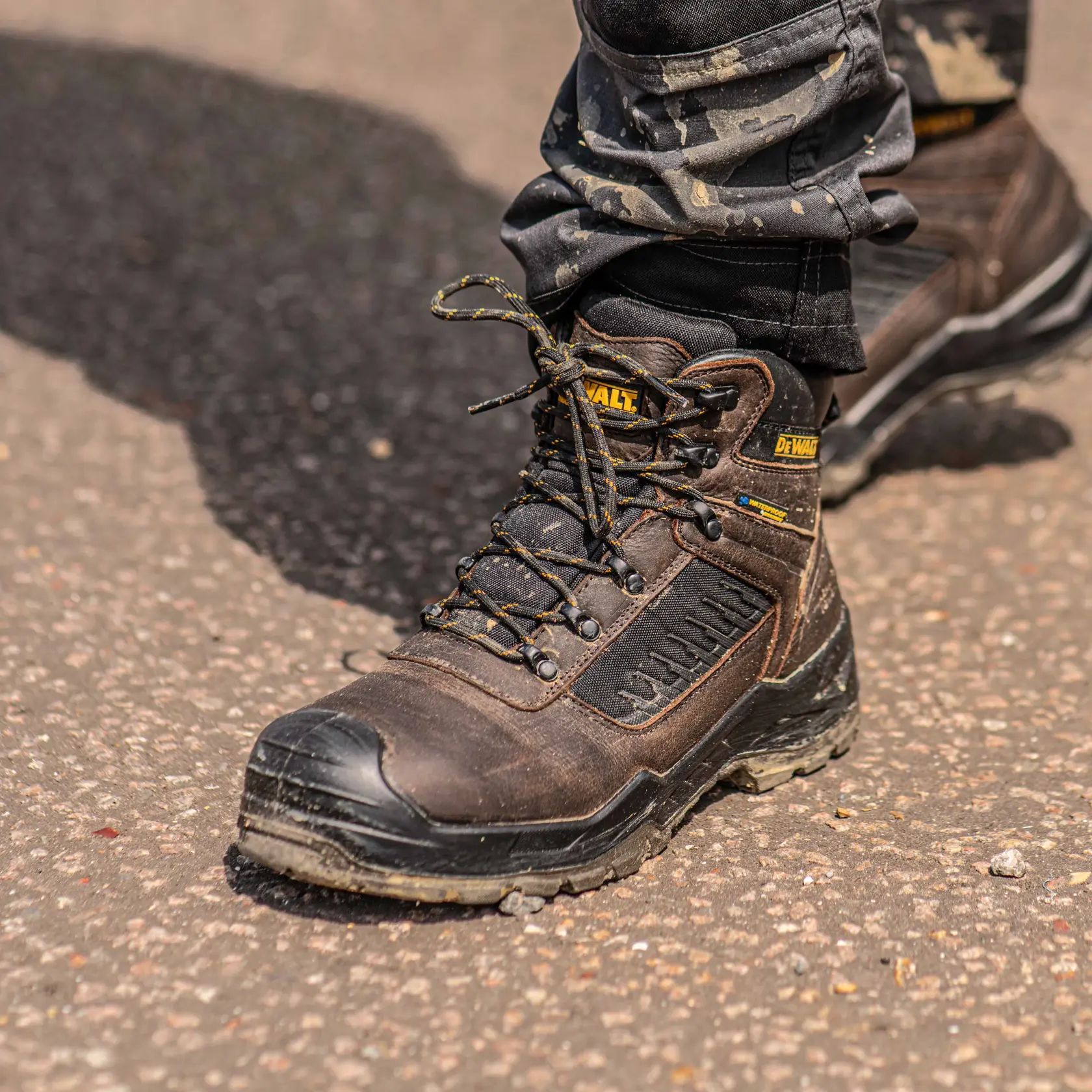 Front view facing left of the DEWALT Reynolds men’s safety boot in brown on model on location
